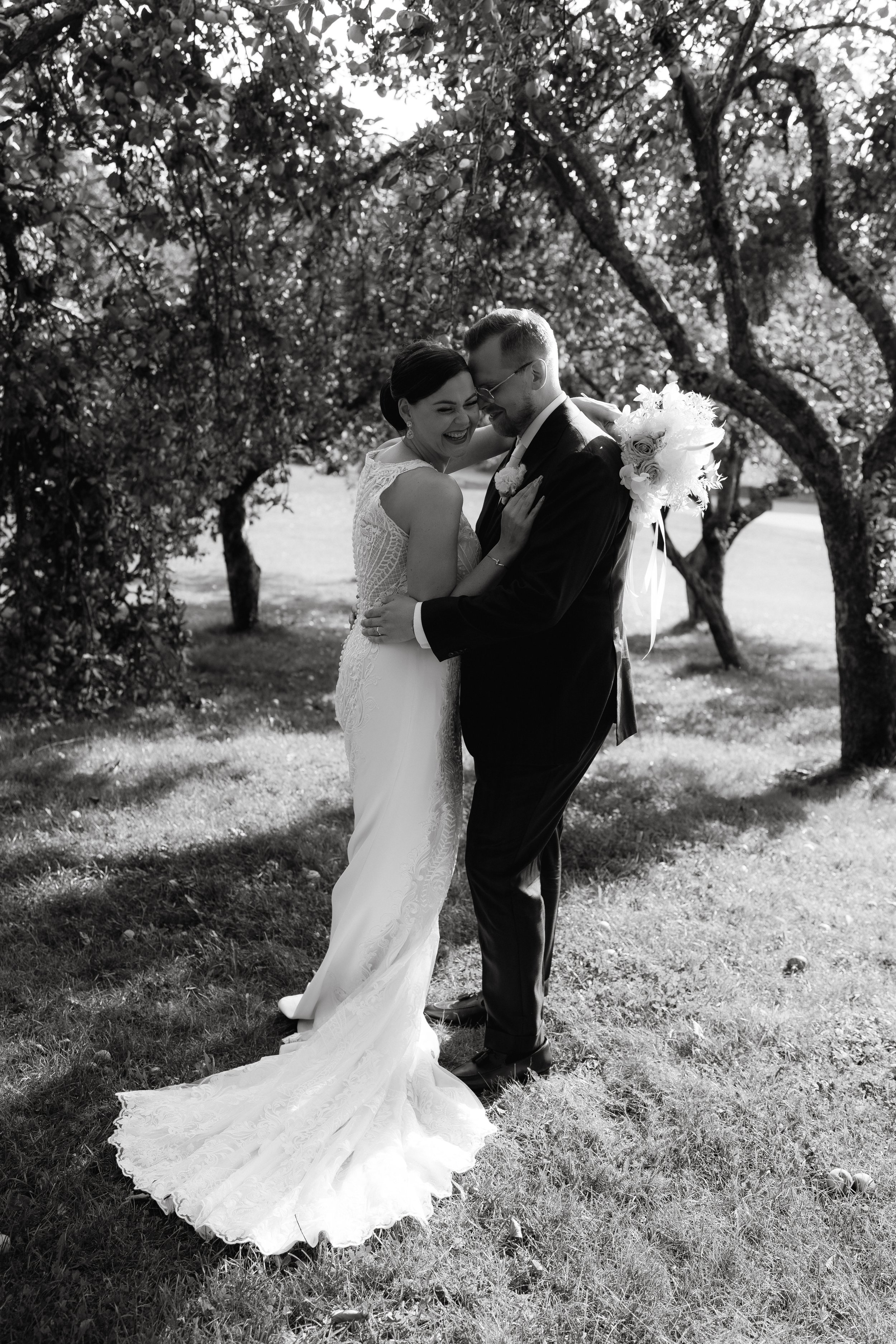 Bride and groom embracing in a garden, black and white photo.