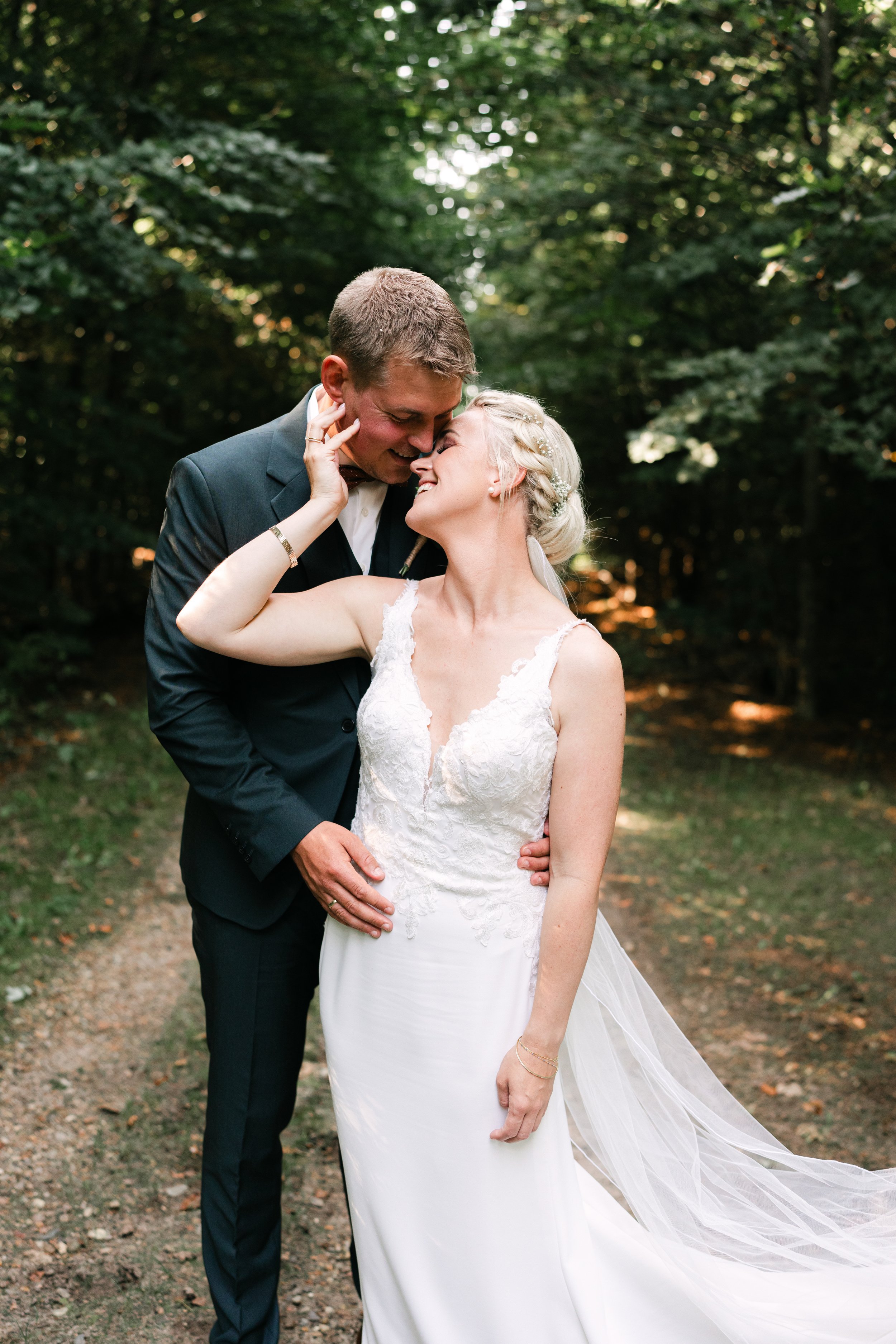Bride and groom embracing outdoors in forest setting