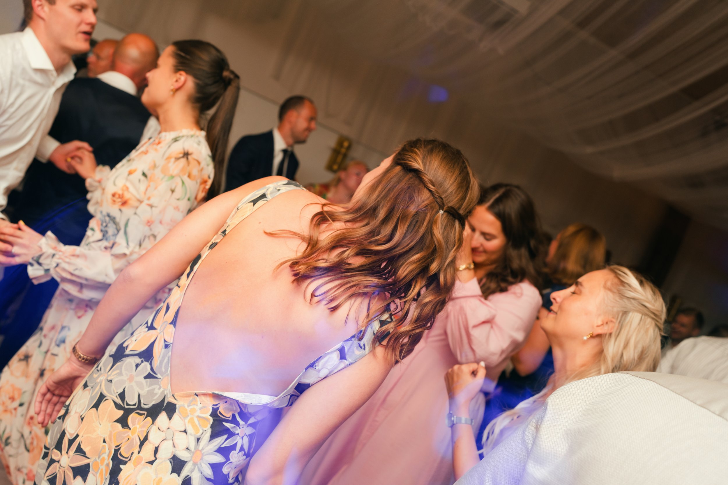 People dancing at a party, wearing formal attire.