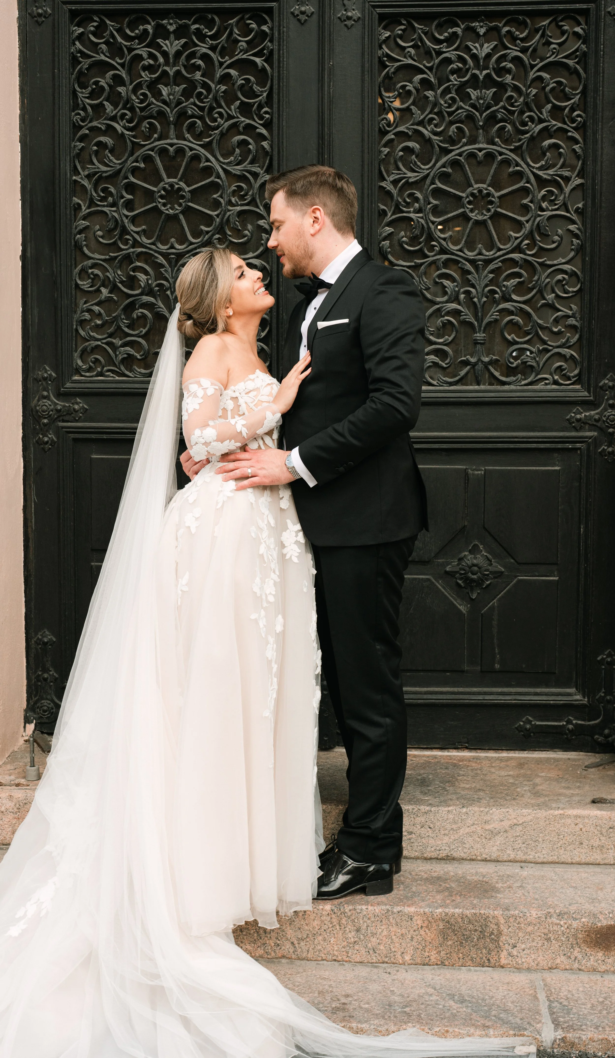 Bride and groom embracing before ornate door