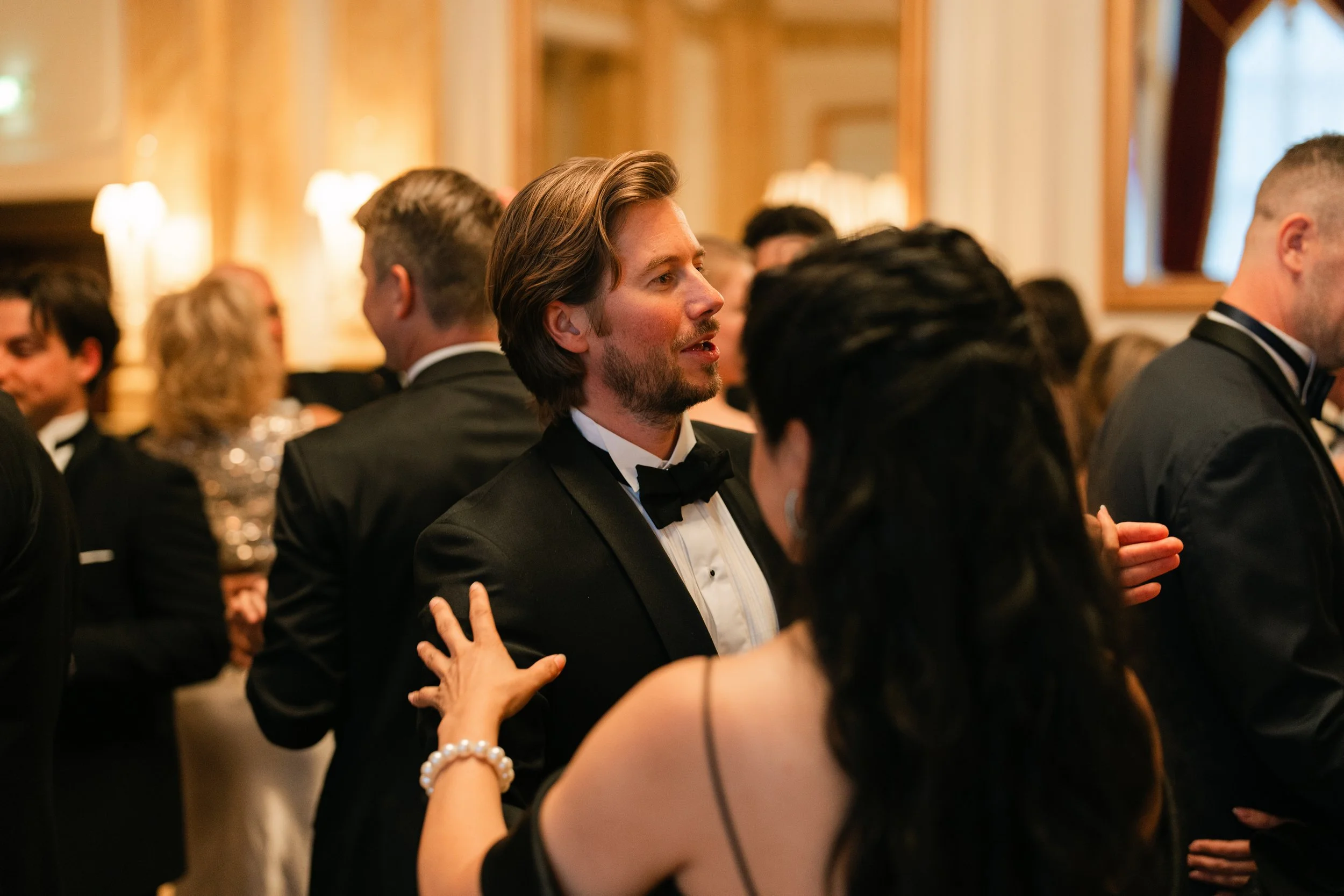 People in formal attire dancing at an elegant party or event.