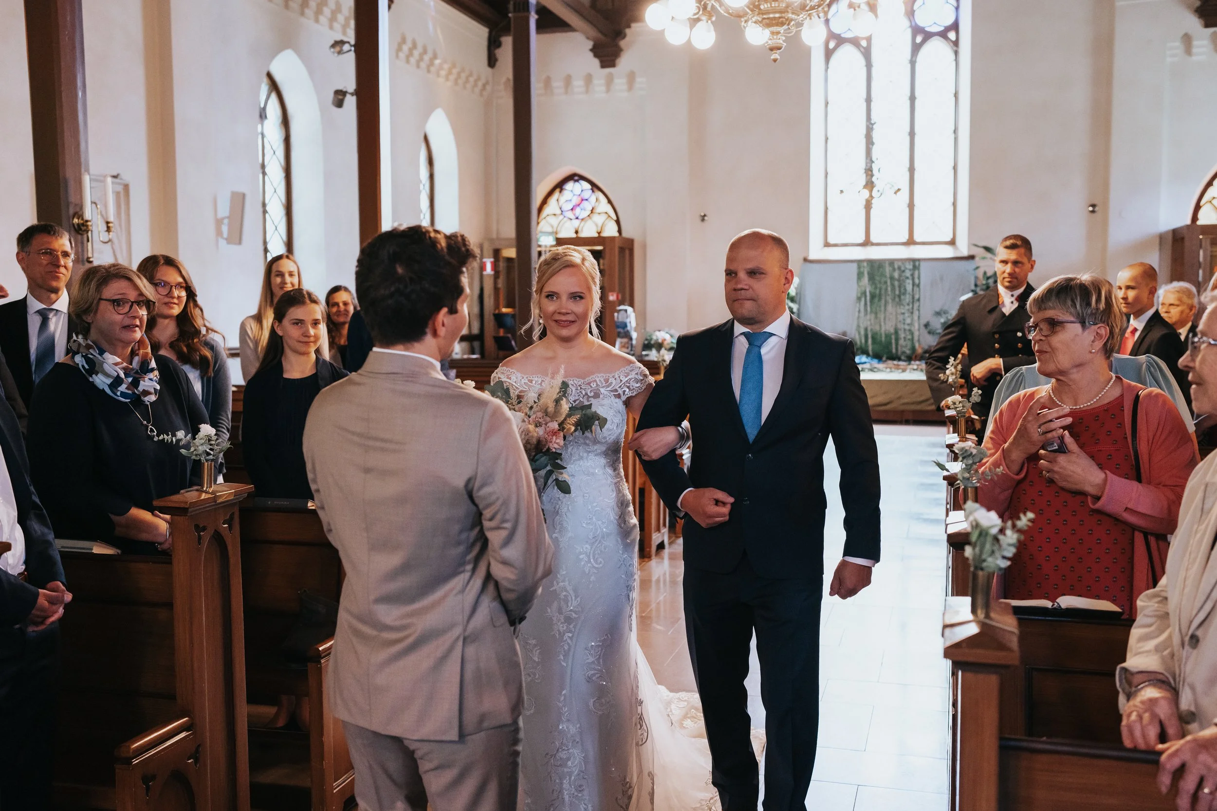 Bride walking down church aisle with guests witnessing