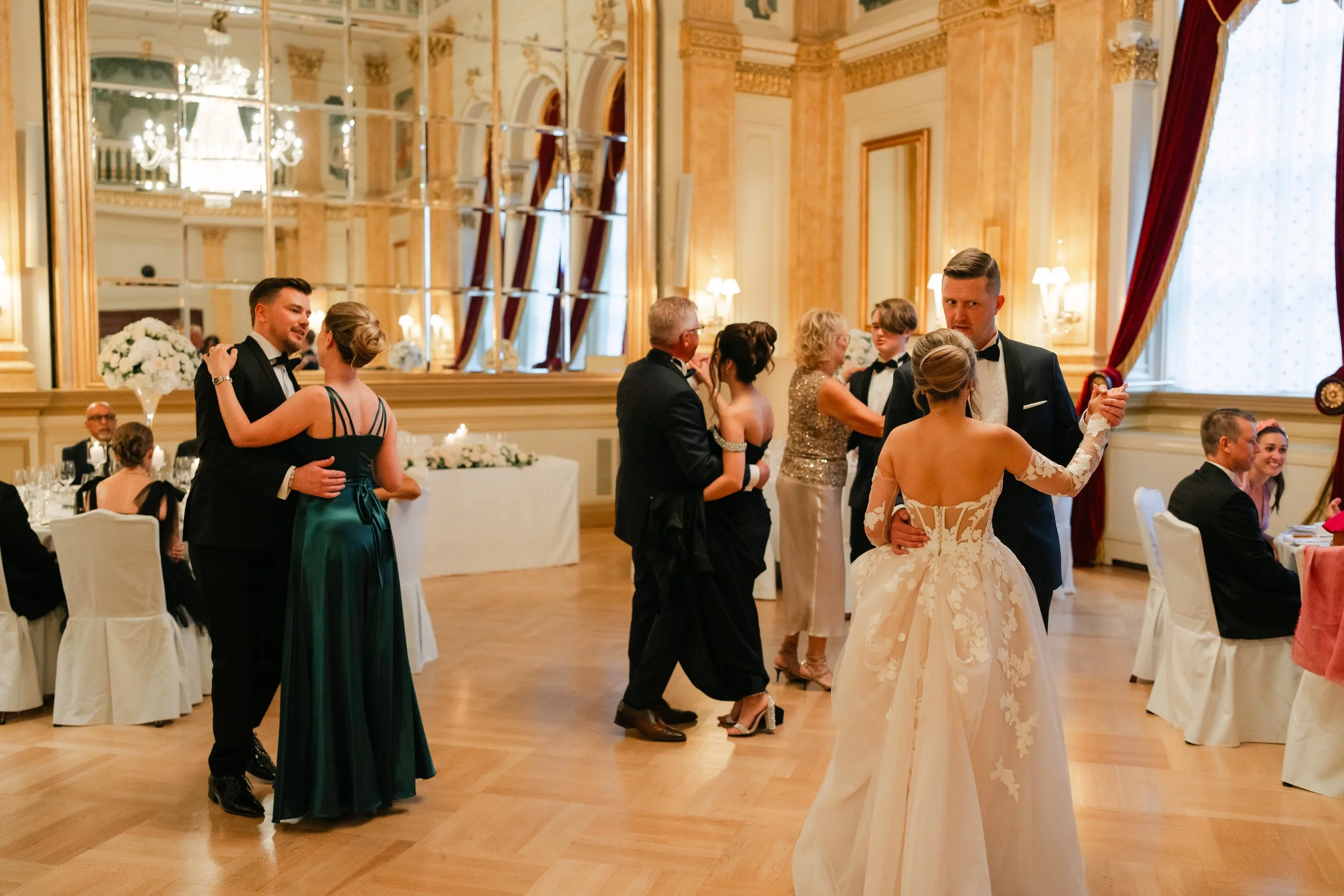 Formal ballroom dance event with couples dancing in elegant attire