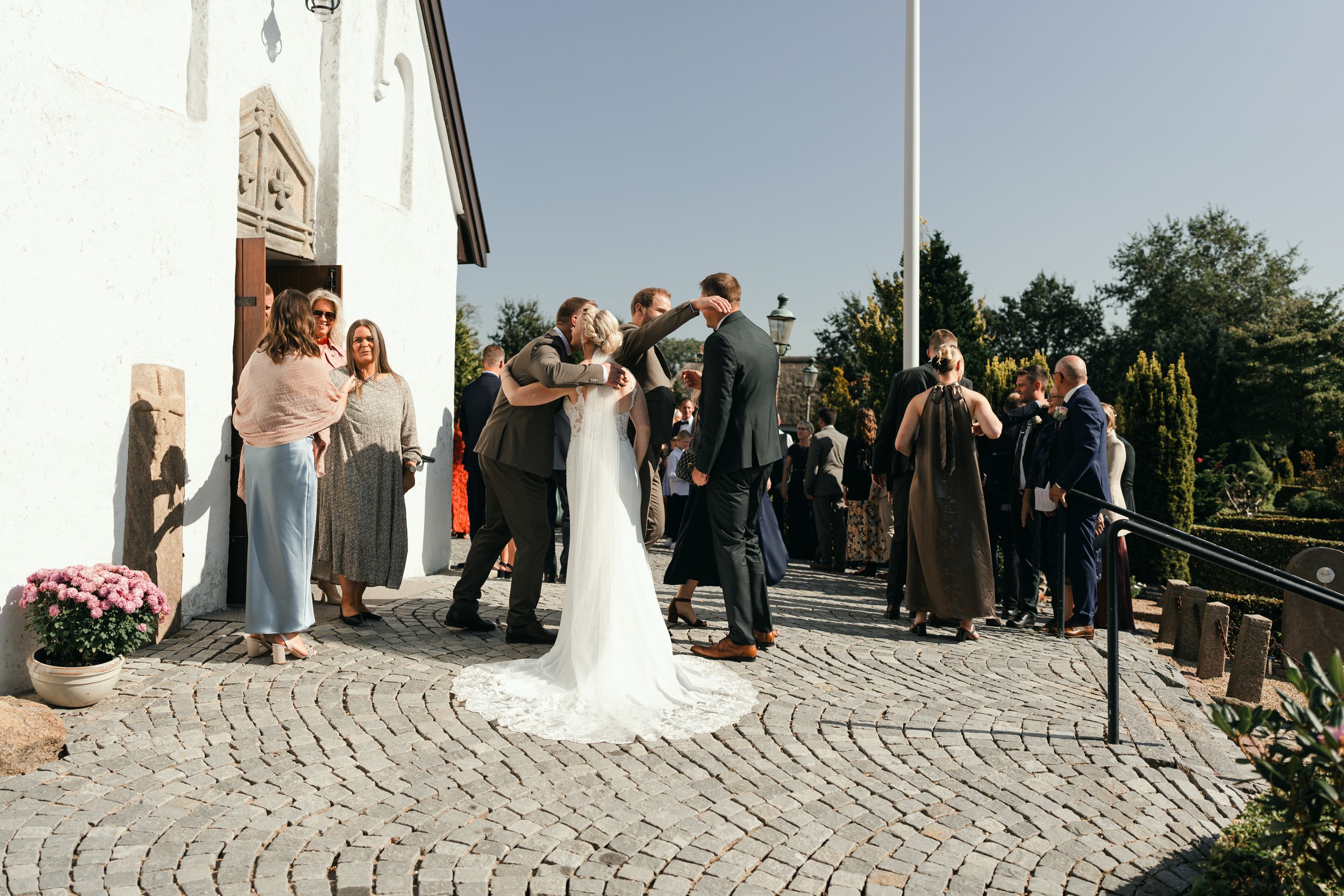 Wedding gathering outside a church; people in formal attire