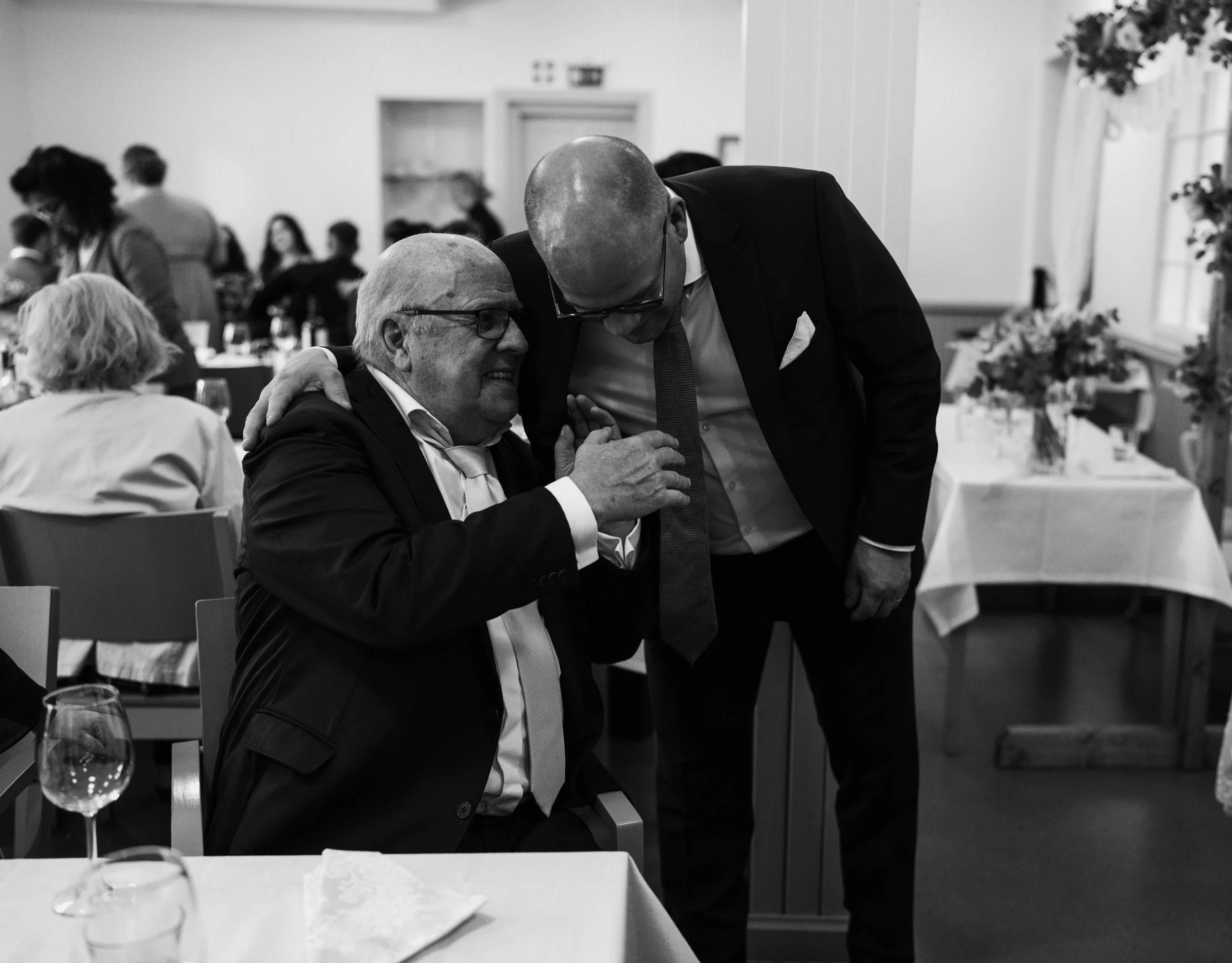 Two men in formal attire sharing a moment at an event.