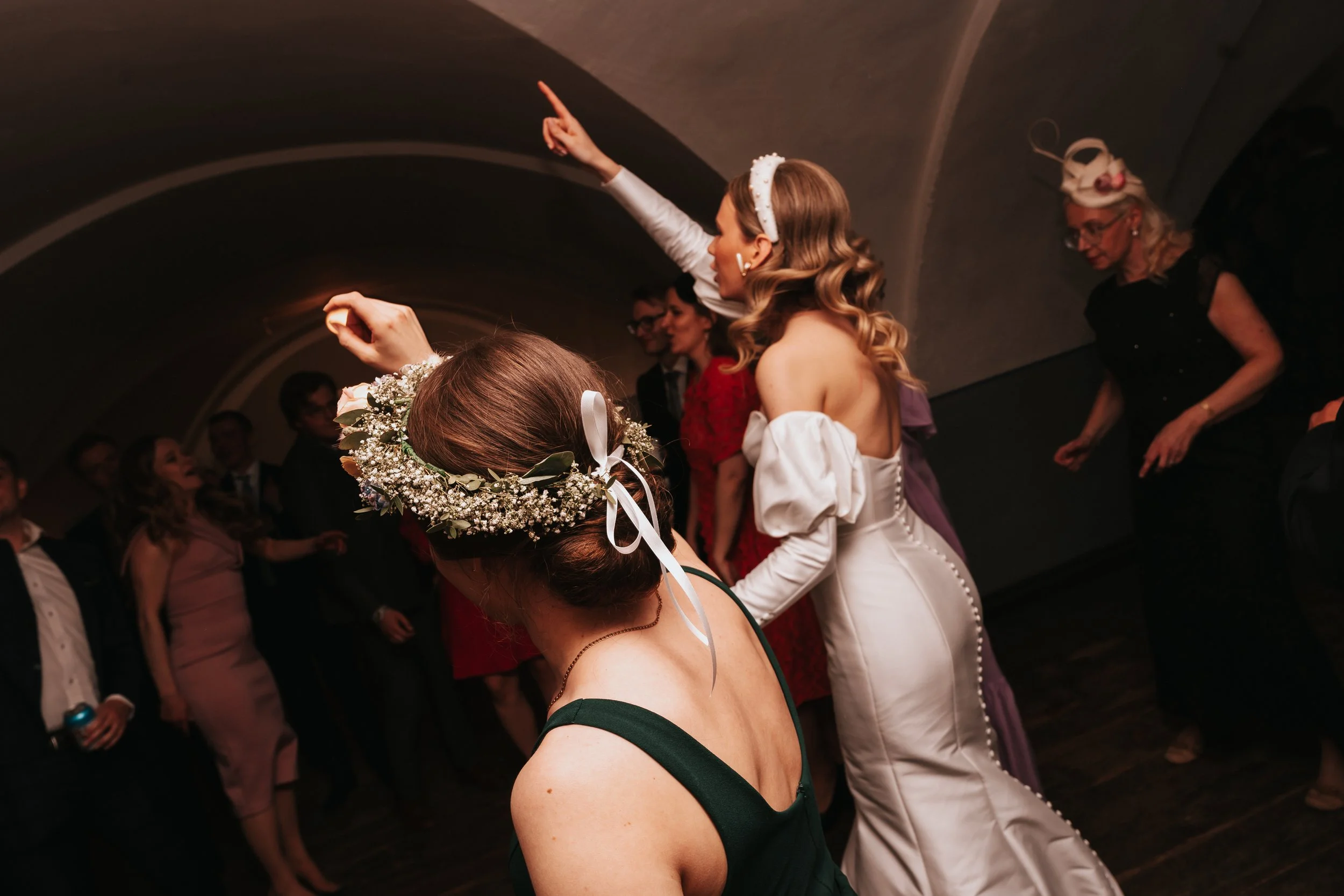 People dancing at a party, woman in white dress pointing