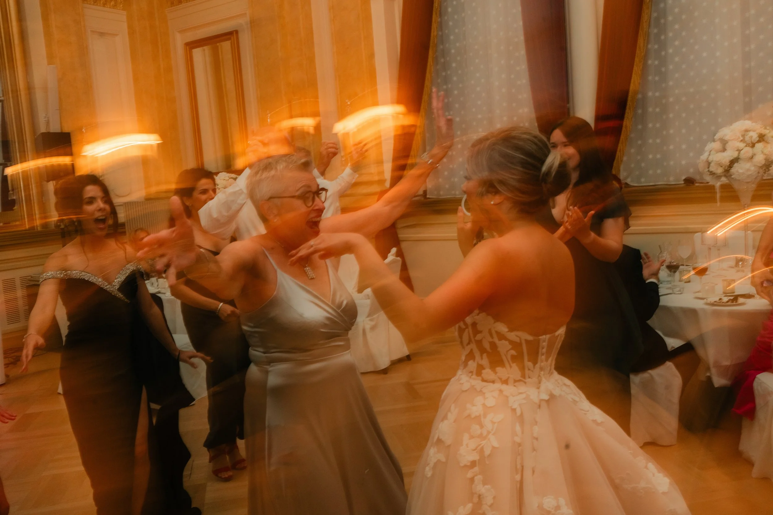 People dancing at a celebration in formal attire.