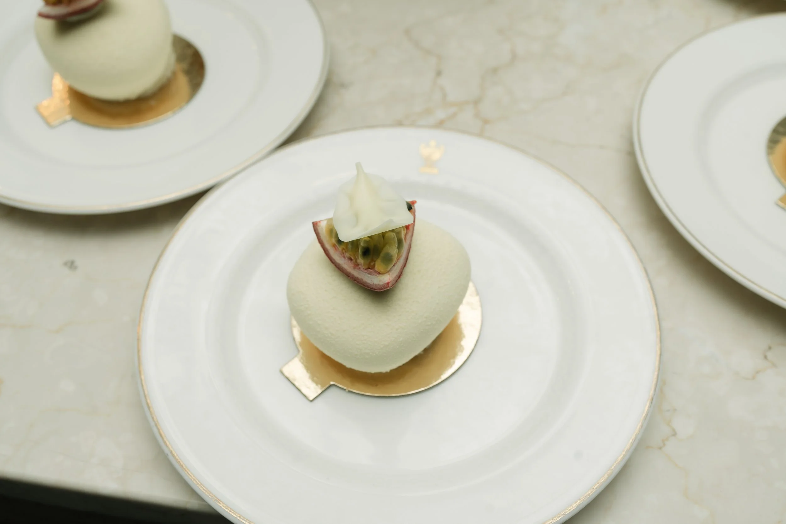 Dessert plated on white dish with passion fruit garnish