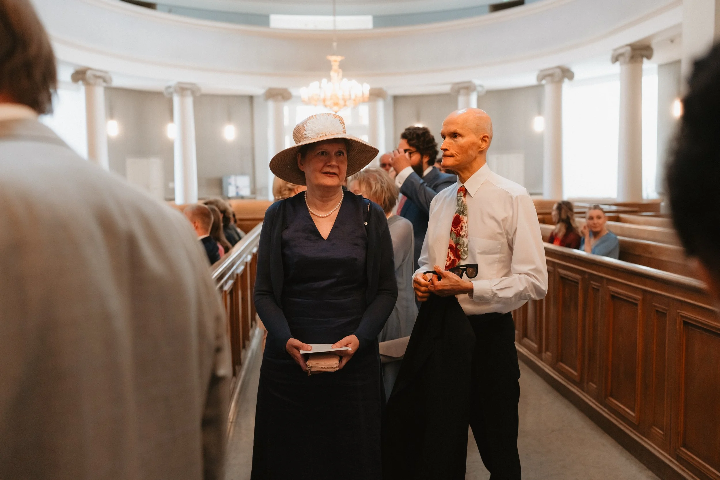 People attending a formal event in a church setting.