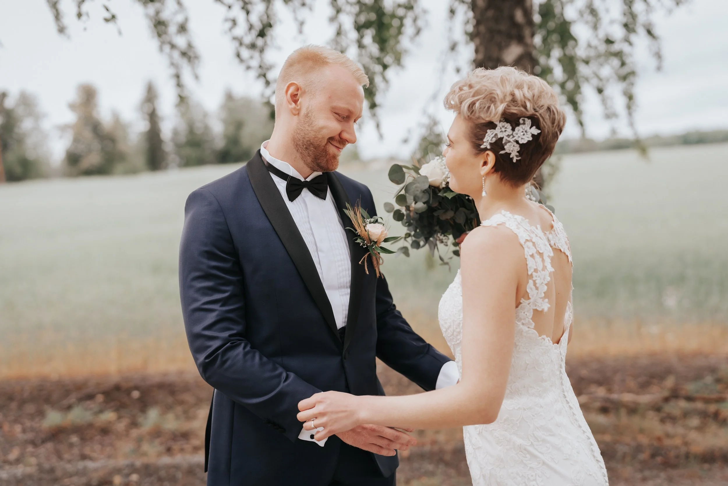 Bride and groom holding hands outdoors in elegant attire