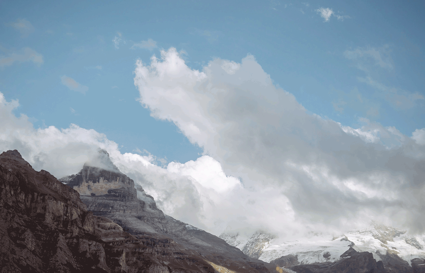 Berglandschaft mit Wolken und blauem Himmel.