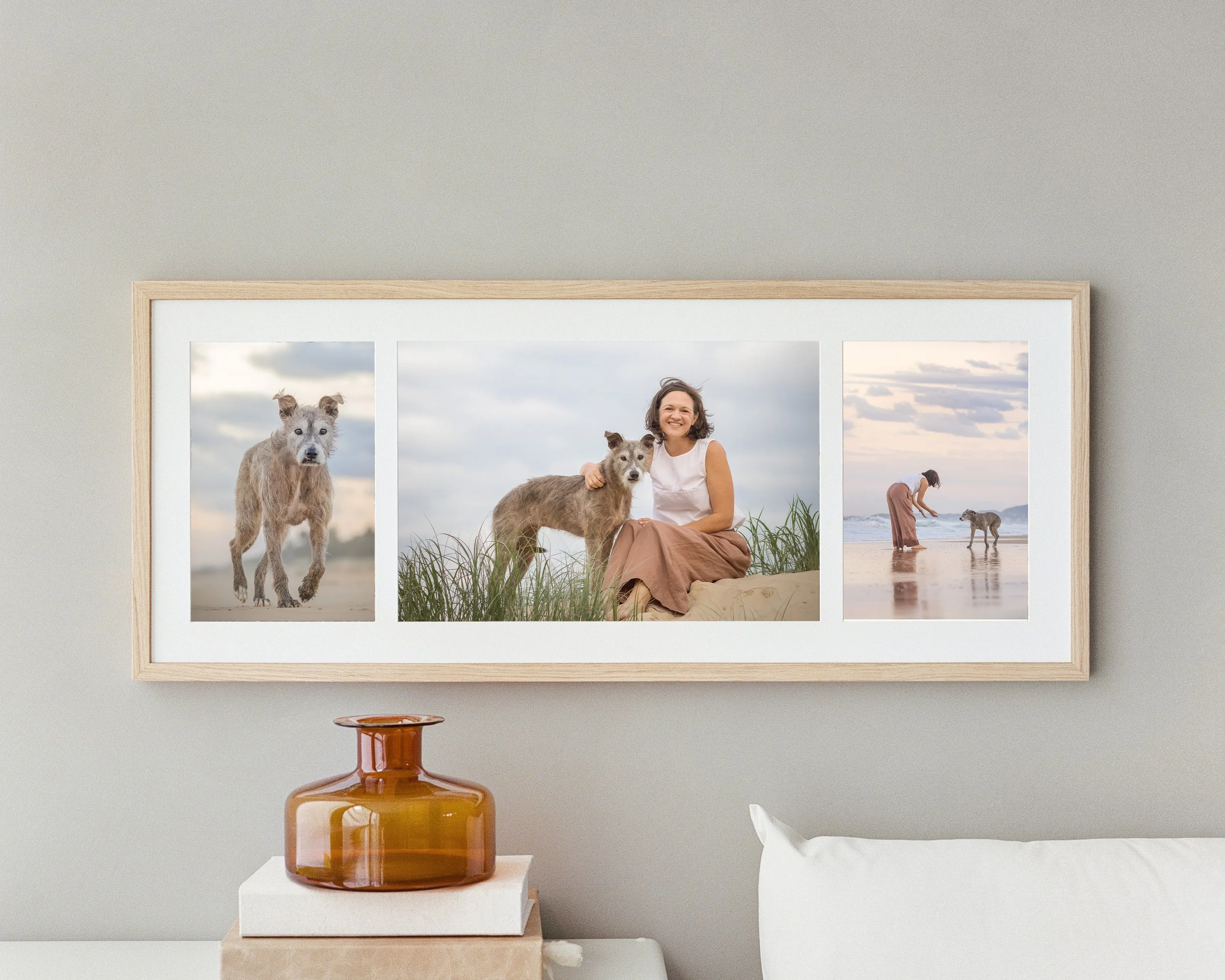 A framed collage of three outdoor photos featuring a woman and her two dogs on the beach, with a cloudy sky background.