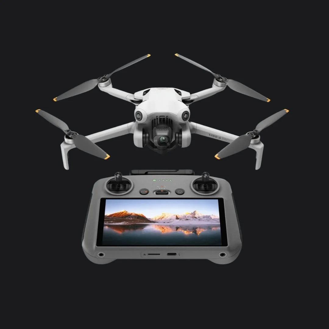 Een drone met vier rotors en een afstandsbediening met een ingebouwd scherm dat een landschap toont.