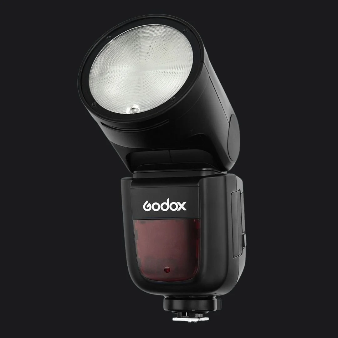 Godox flitser voor camera, zwart, schuine kop, productfoto op donkere achtergrond.