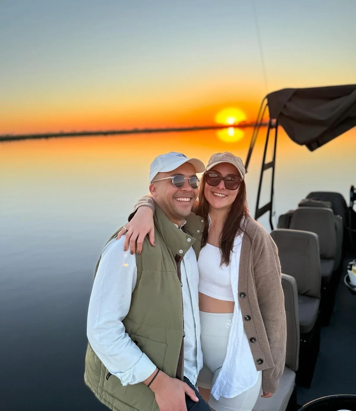 Beyond the Baobab founders Kristy and James Briscoe smiling and relaxed on a custom safari boat during a water-based game viewing experience in Botswana.