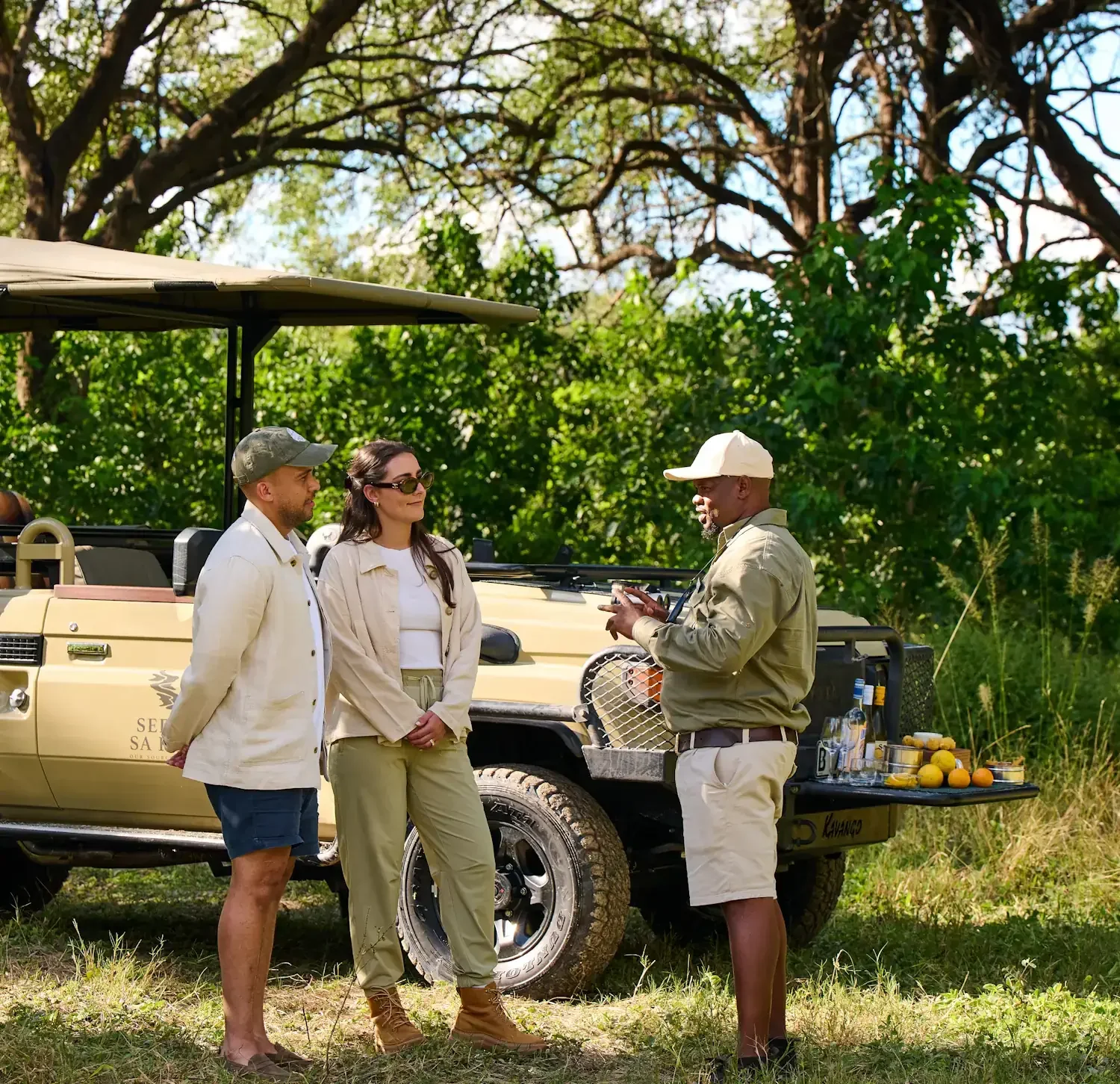 A portrait of Beyond the Baobab founders James and Kristy Briscoe smiling together outdoors during a bespoke luxury Botswana safari.