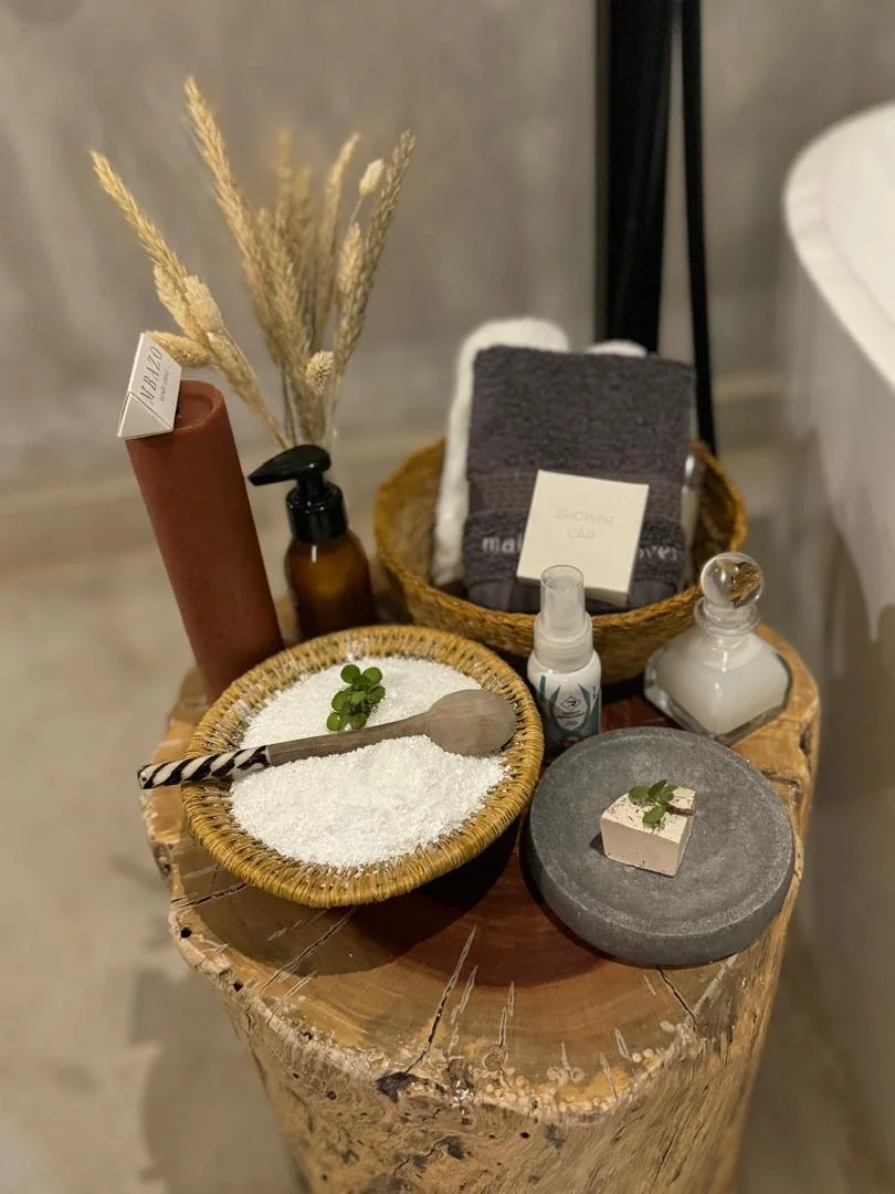 Premium spa bath amenities and natural products arranged in woven baskets inside a luxury safari lodge
