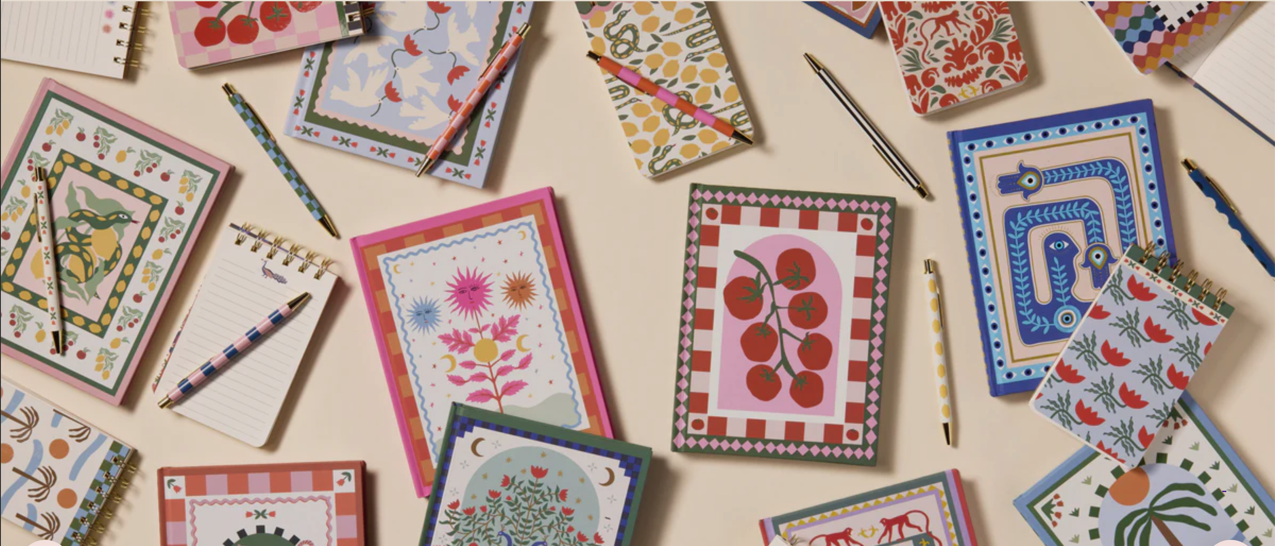 Notizbücher und Stifte mit farbenfrohen, dekorativen Covern und Mustern.