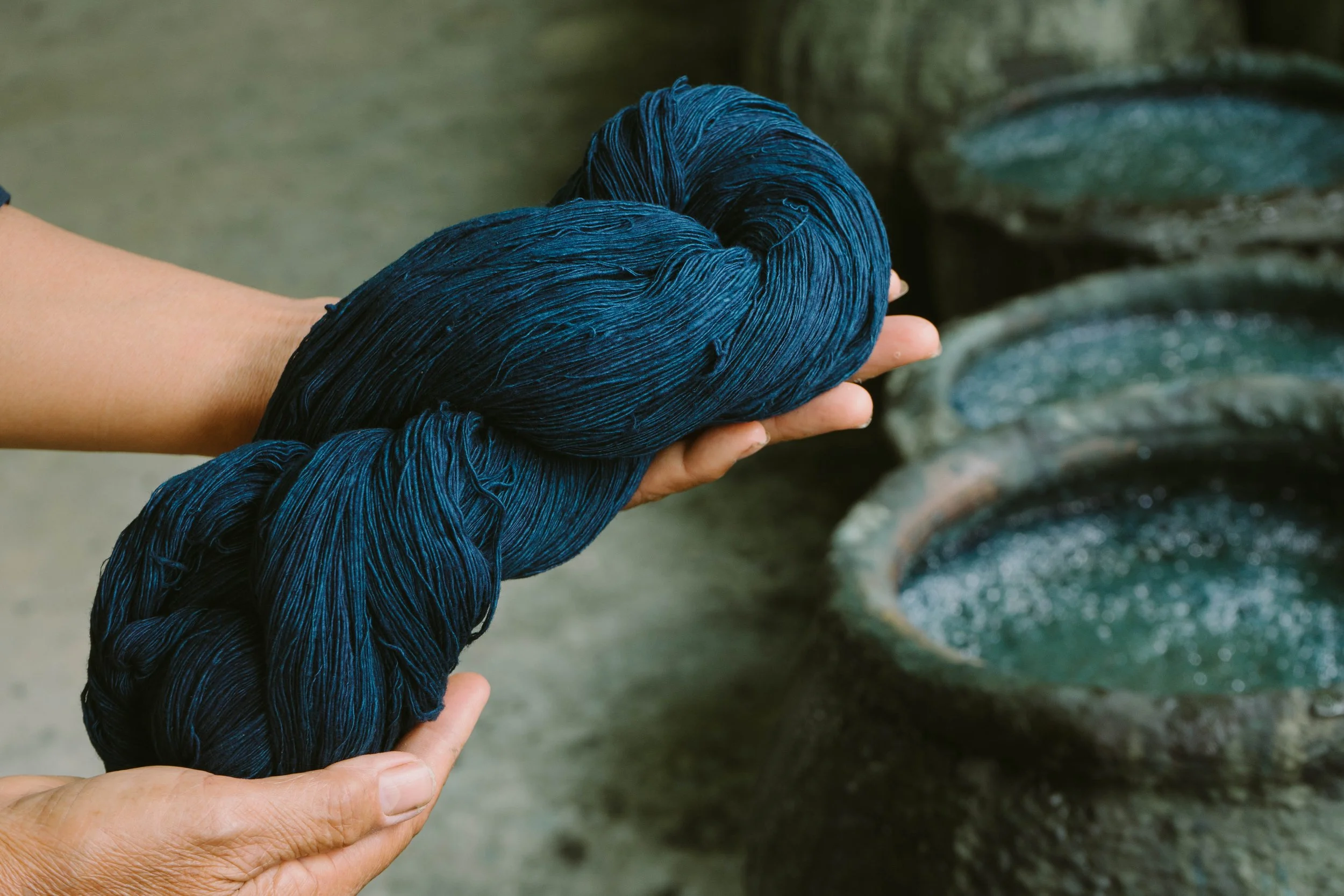 Hände die gefärbtes Garn hochhalten