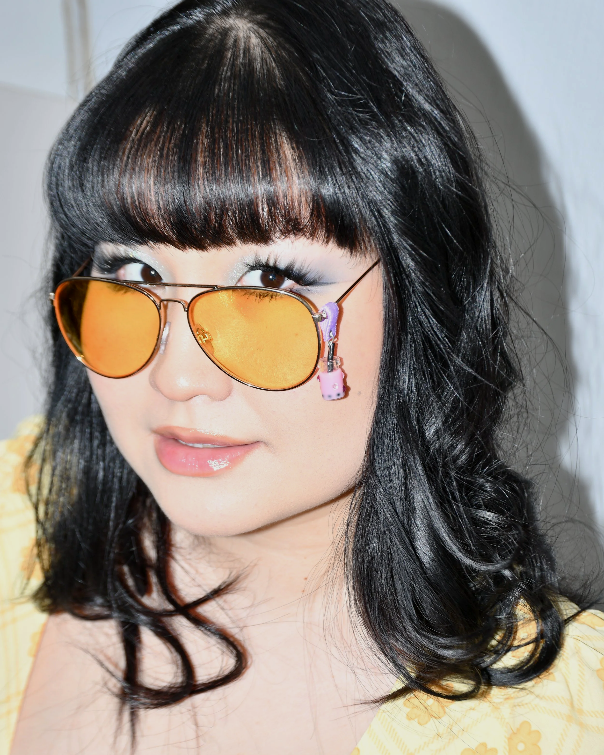 girl wearing yellow glasses with Dragon Fruit Boba Tea Charm attached to purple soft fabric holder