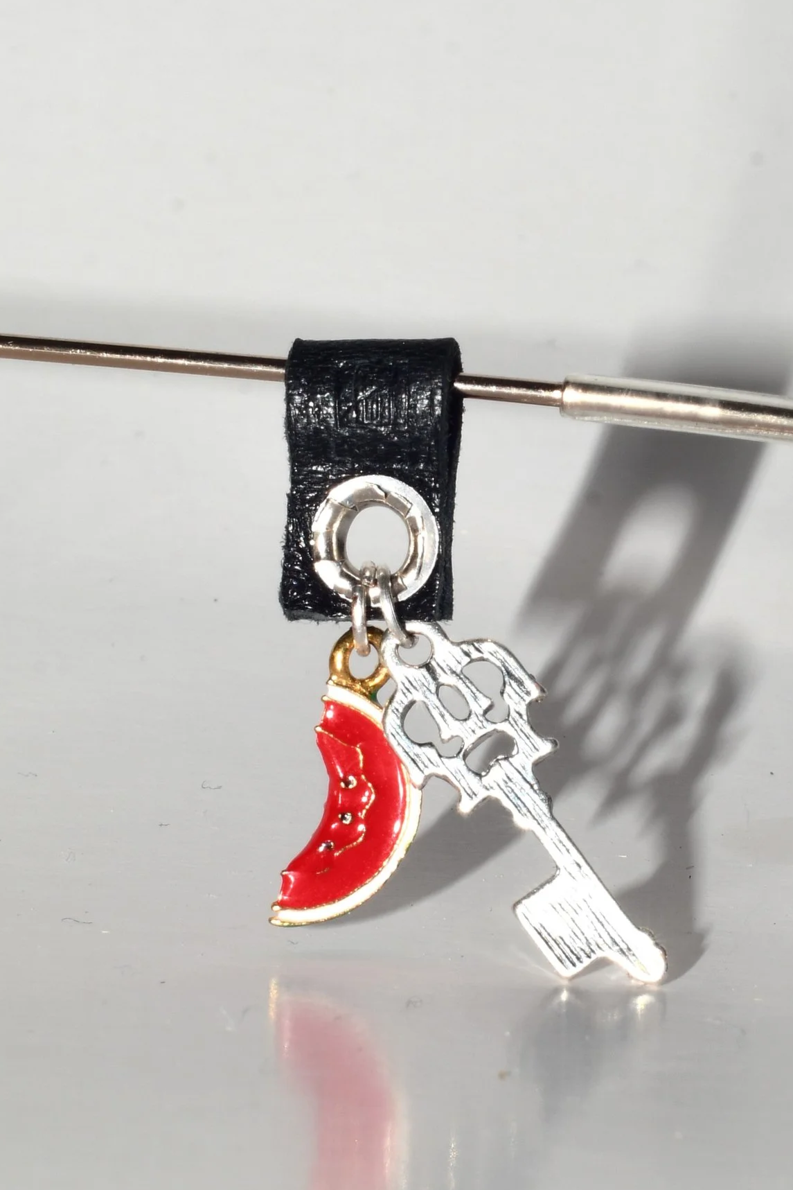 La Tâj handcrafted eyewear jewellery with leather attachment, silver key charm, and multicolour watermelon pendant on eyeglasses.