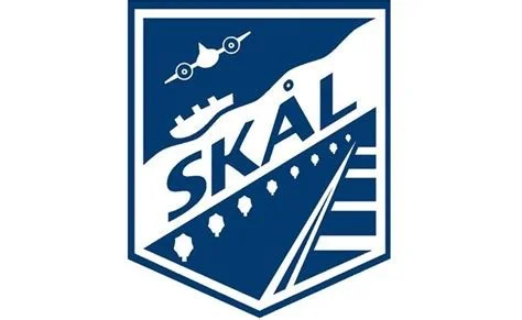 Logo featuring the word 'SKÅL' with a plane, ship, and road design