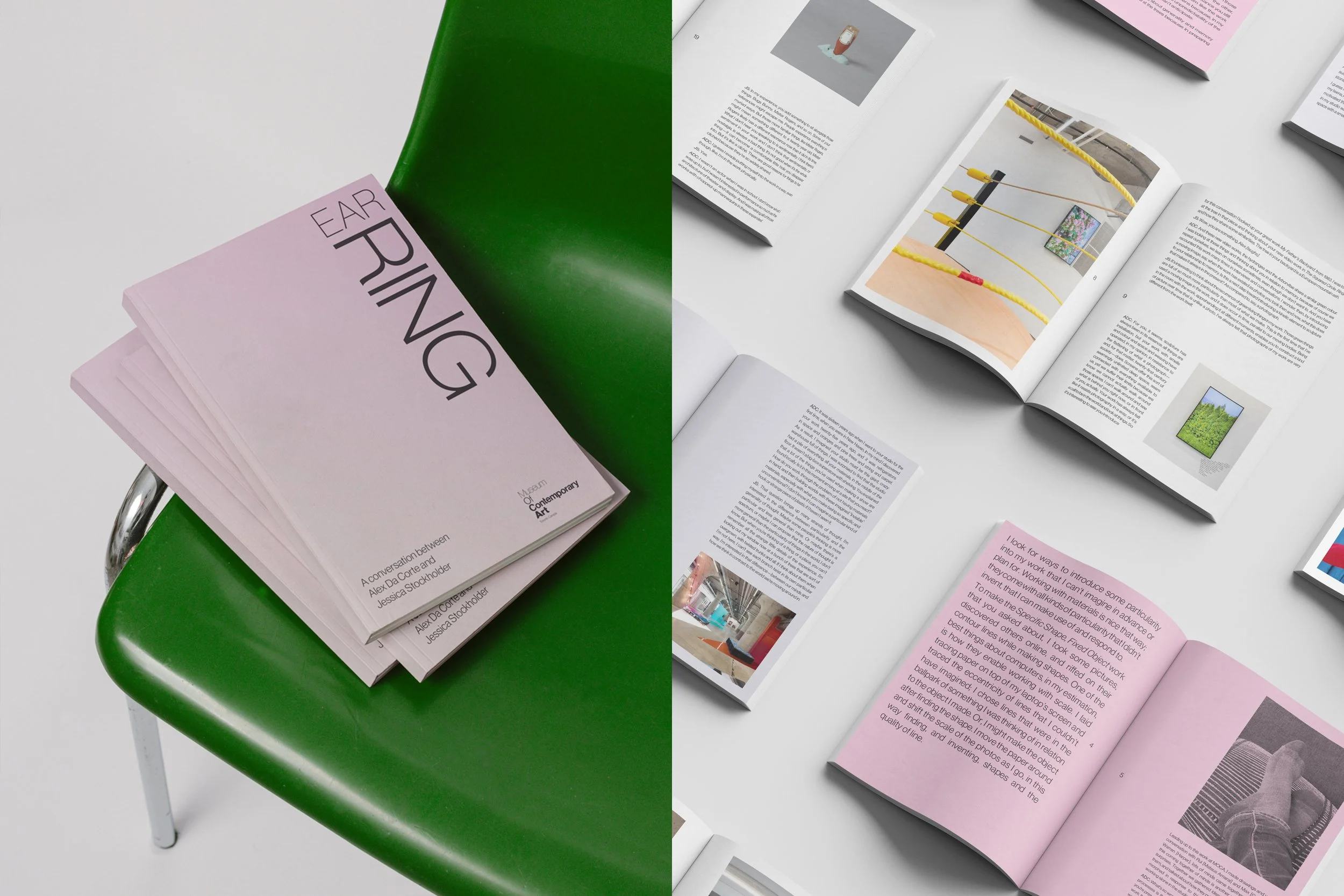 An open magazine on a white table displaying text and images, with pink pages and some green element nearby, and additional open magazines scattered on the table.