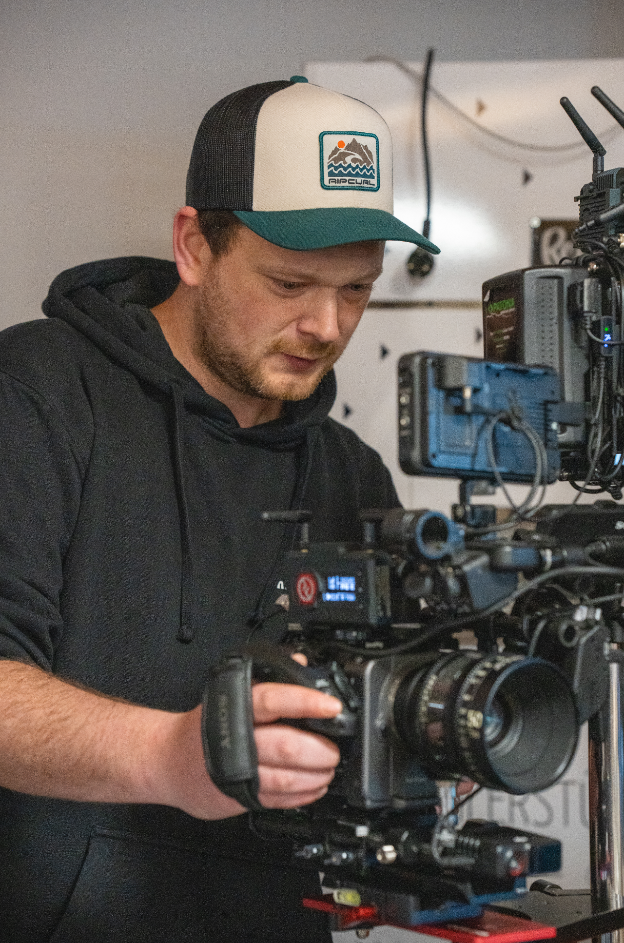 Ein Mann mit Baseballcap, der eine professionelle Videokamera bedient. mila motions Werbefilmproduktion