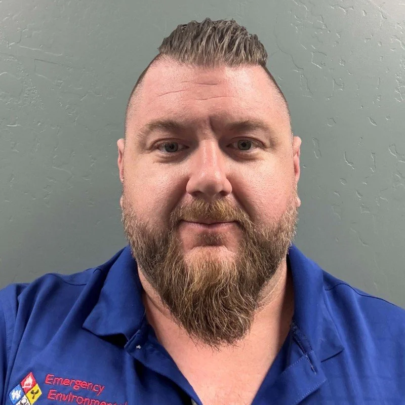 Man in a light suit and black tie against black background