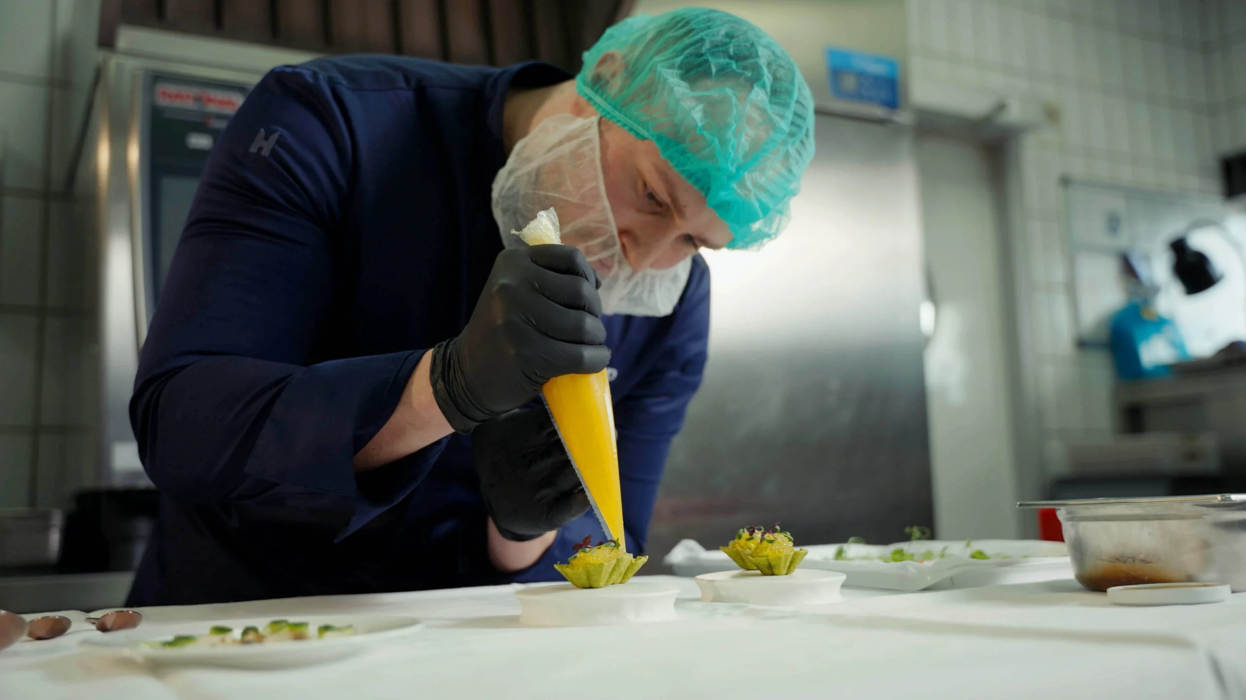 Chefkoch richtet hochwertige Gerichte für eine Produktpräsentation an.
