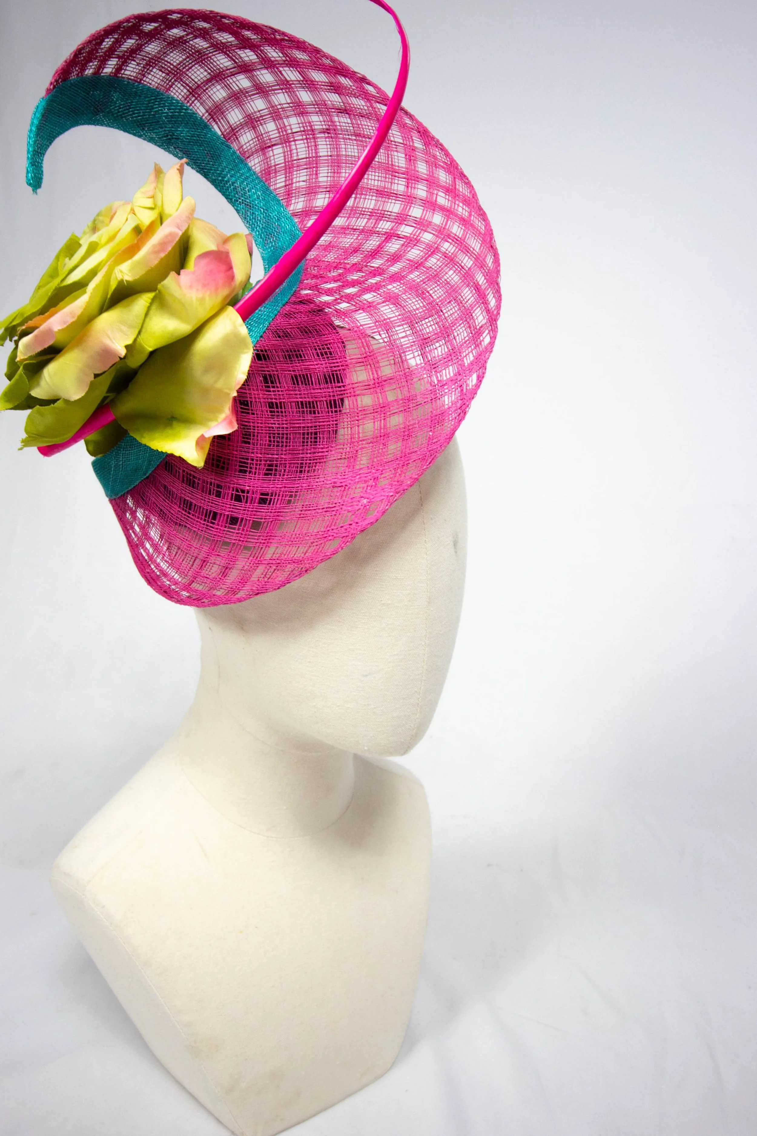 A hot pink straw swirl with a turquoise edge. There is a curly quill in a matching hot pink and a large acid green and pink flower- very bright!