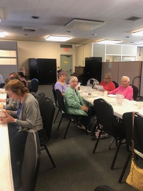 prime timers luncheon - people eating, woman smiling at camera