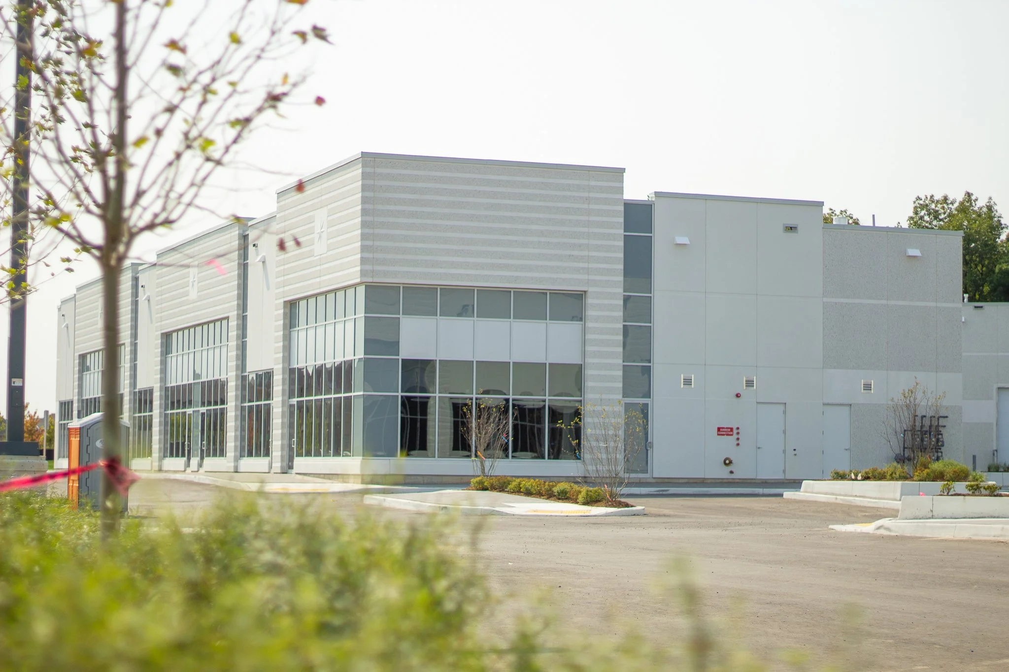 An empty commercial building with large glass windows on a clear day.