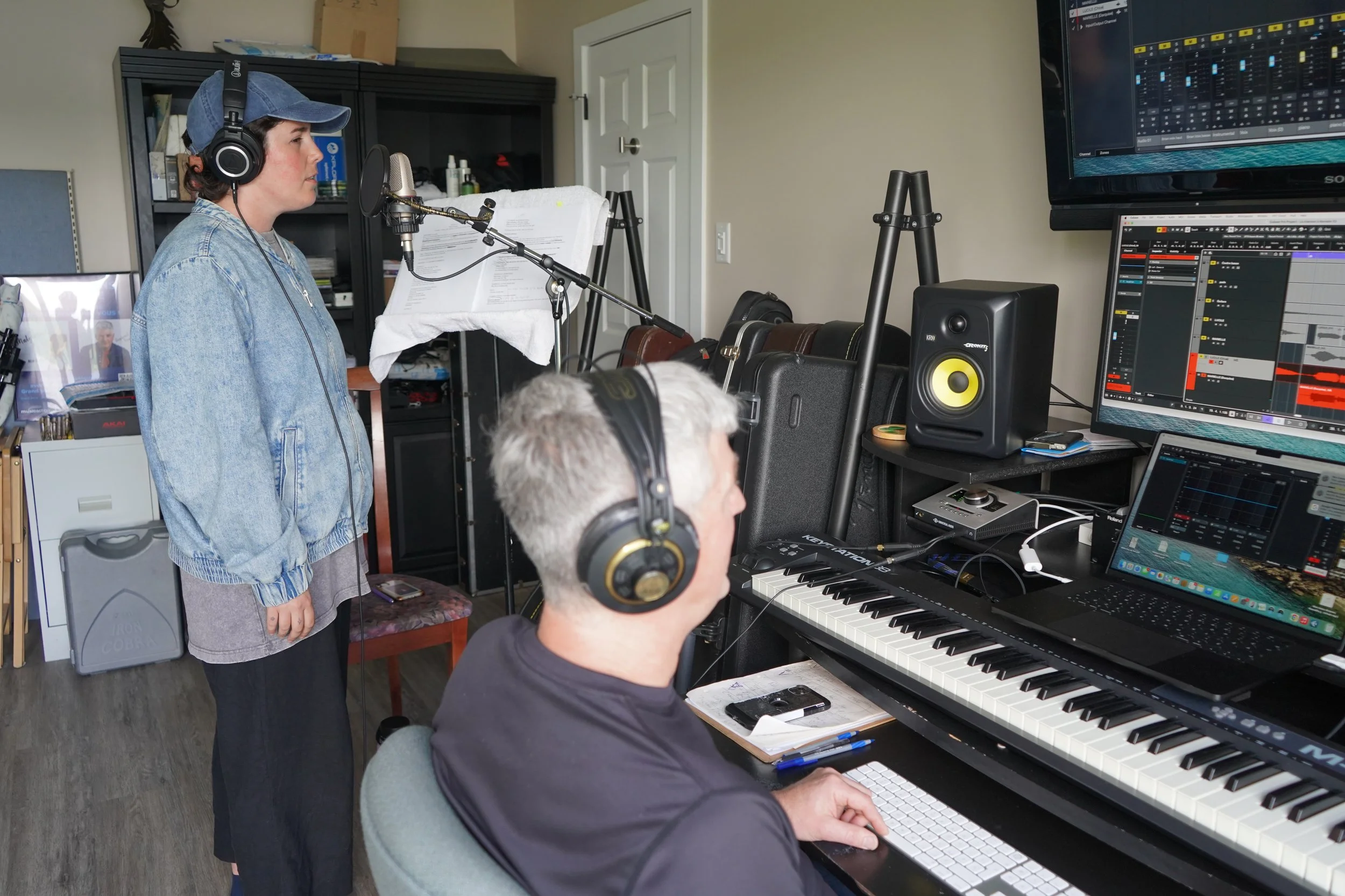Une personne au casque écoute de la musique en studio, une femme chante devant un microphone, deux écrans affichent des logiciels de musique, et une personne joue du clavier.