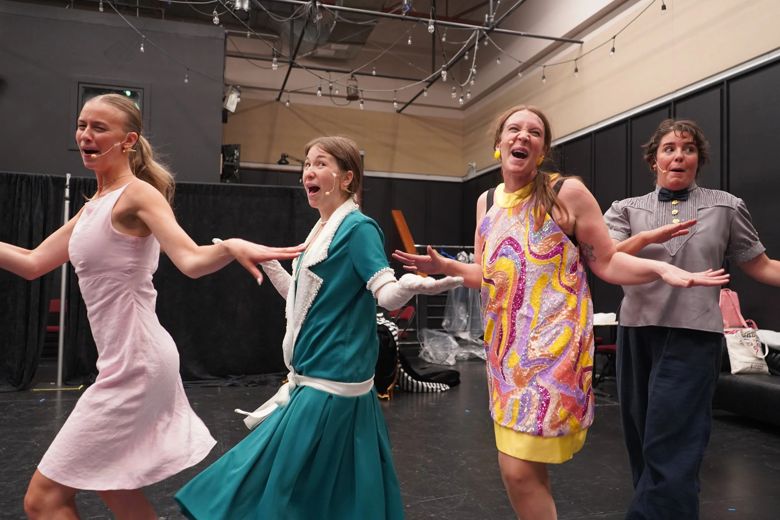 Groupe de quatre personnes théâtre sur scène, posant avec expressions expressives, ambiance de spectacle.