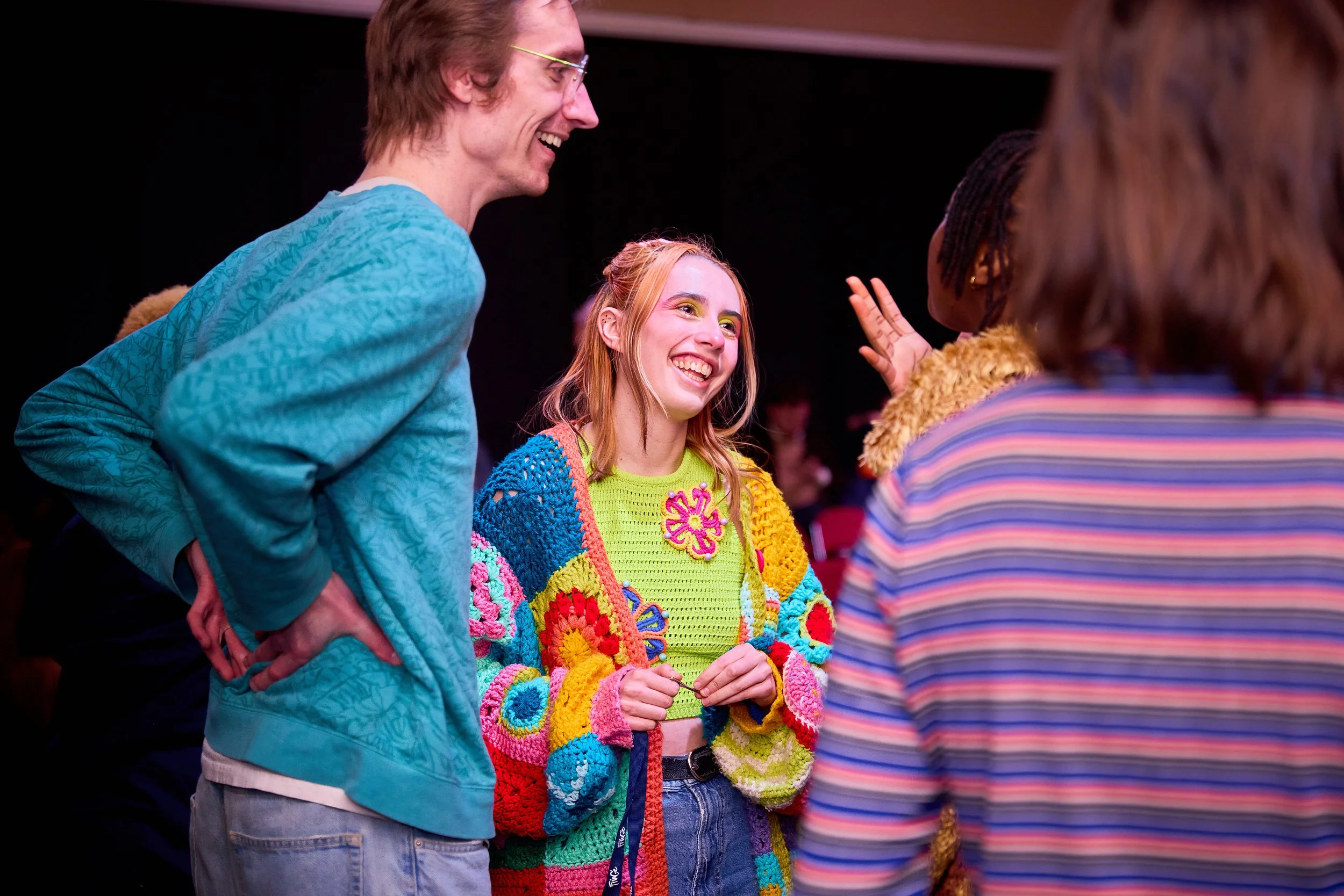 Groupe de jeunes adultes souriants et discutant dans une ambiance conviviale.
