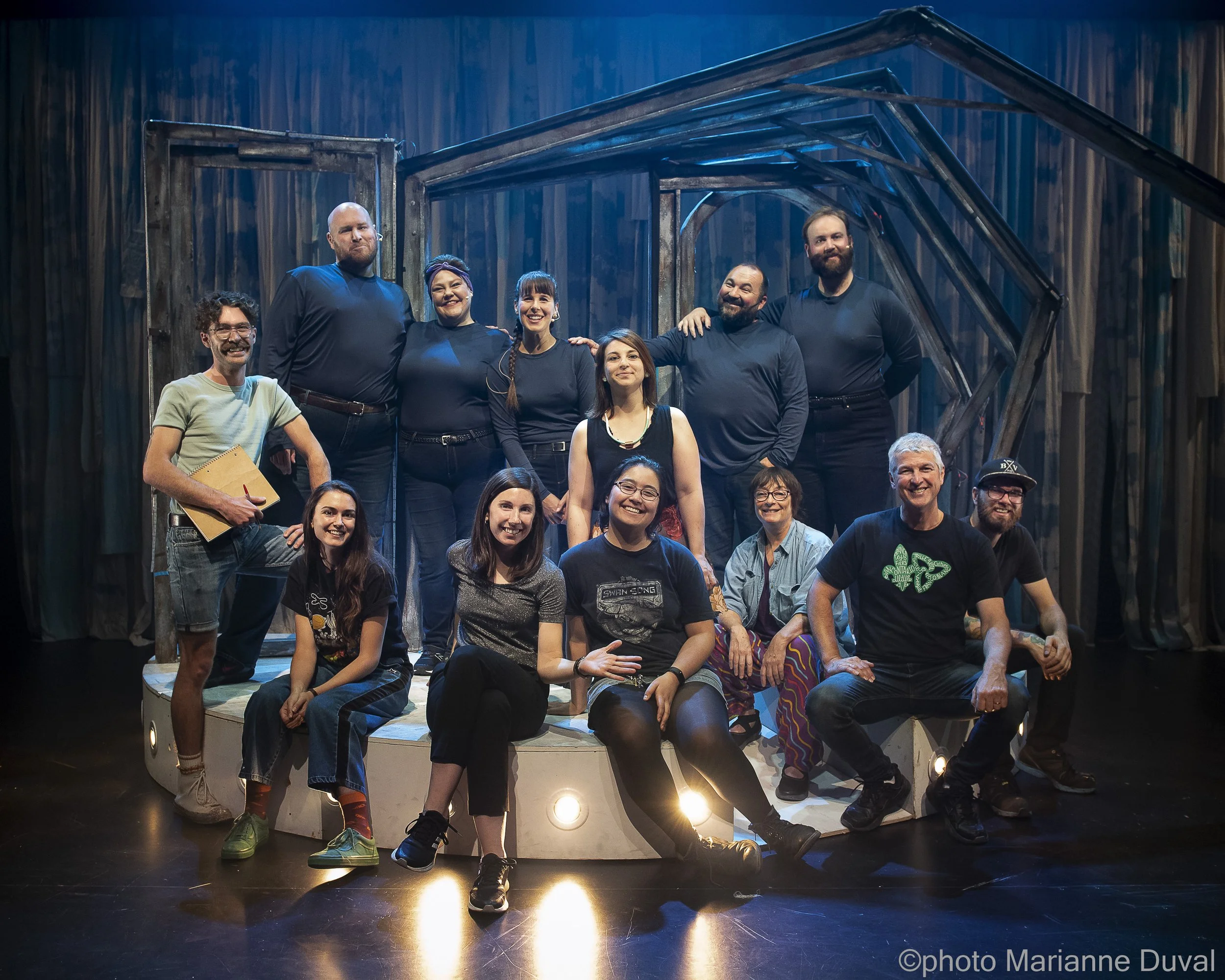 groupe de personnes sur scène en costume de théâtre, posant pour une photo de groupe