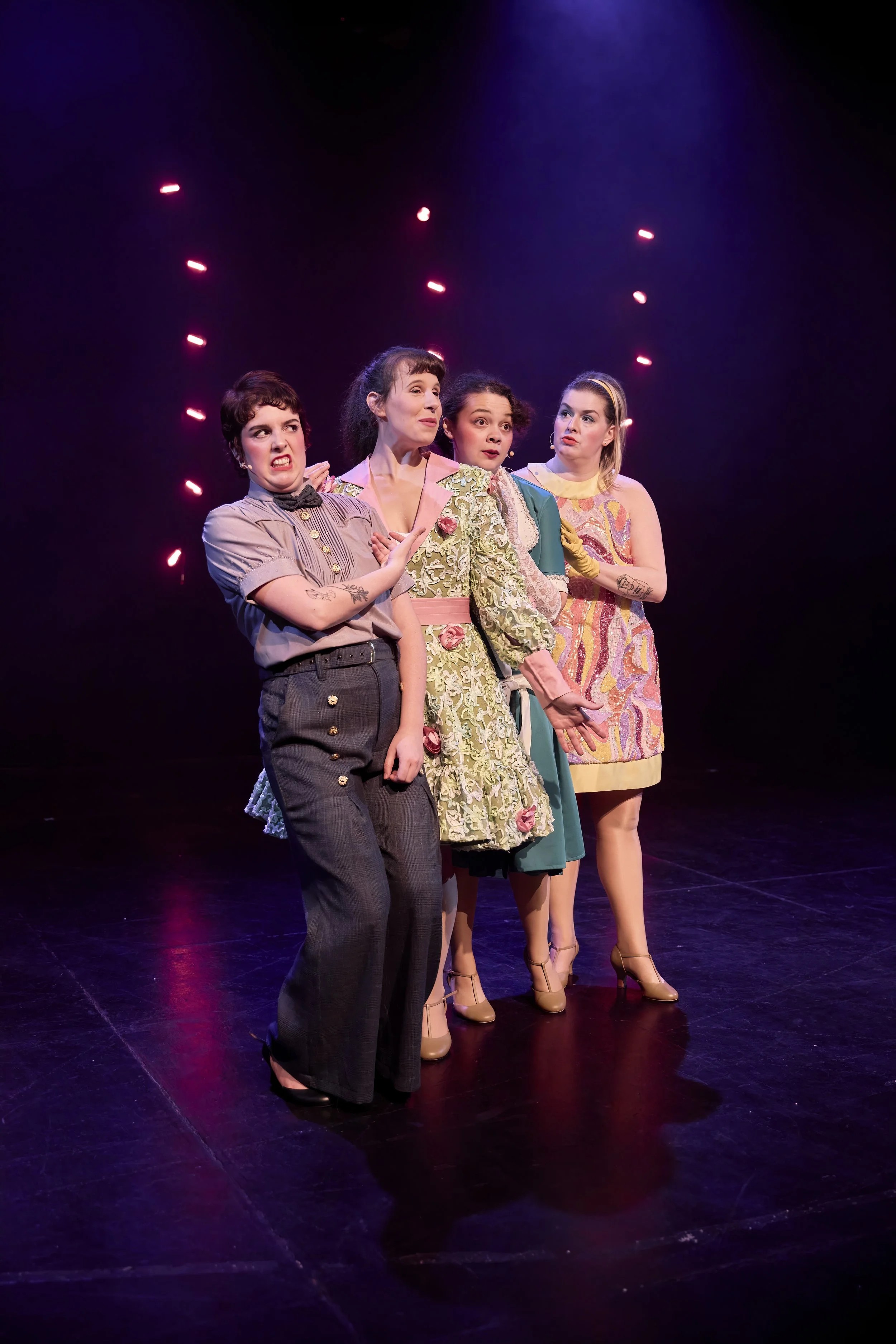 Créations In Vivo. Quatre femmes en costumes théâtraux sur scène avec des expressions faciales dramatiques.