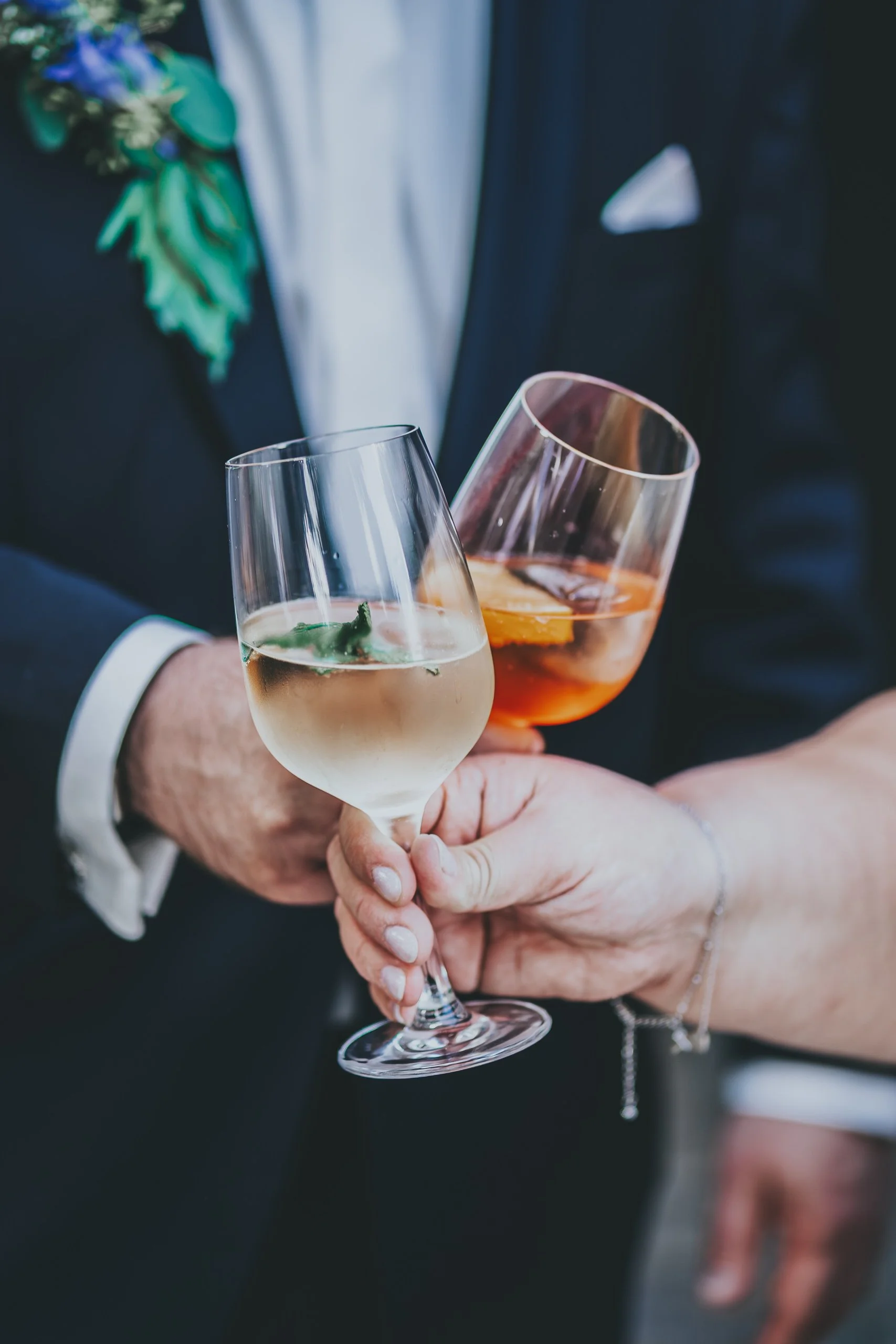Zwei Menschen halten Gläser mit Wein und Aperitif, bei einer Feier oder einem besonderen Anlass.