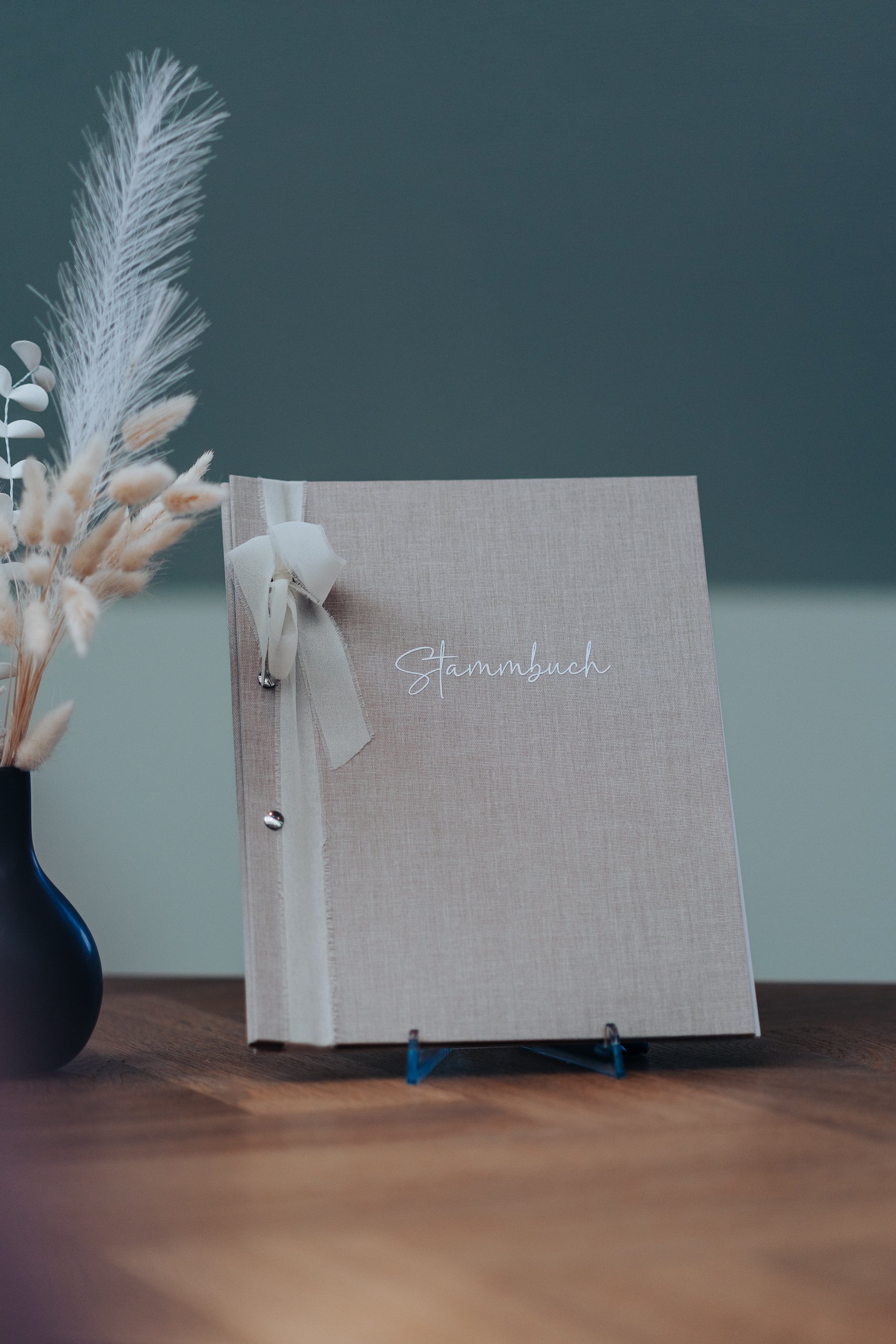 Stammbuch zur standesamtlichen Hochzeit neben einer Vase mit Gräsern.
