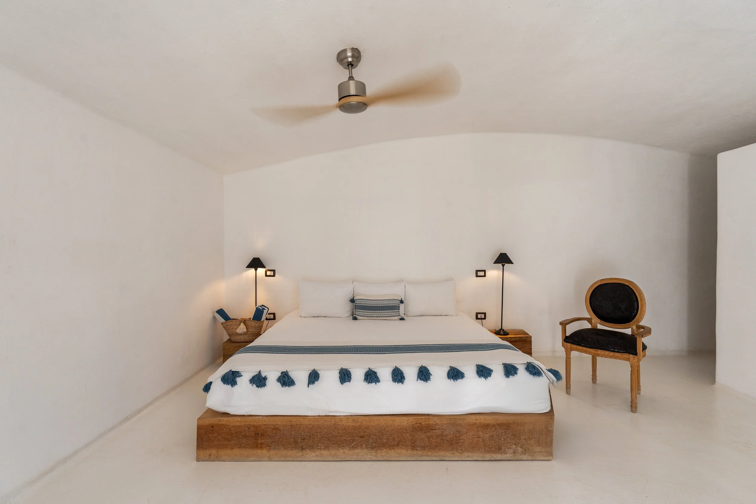 Interior view of the NEST Suite Ocean View at NEST Baja, featuring a king-size bed with blue accents, soft lighting, and minimalist design that evokes calm and comfort.