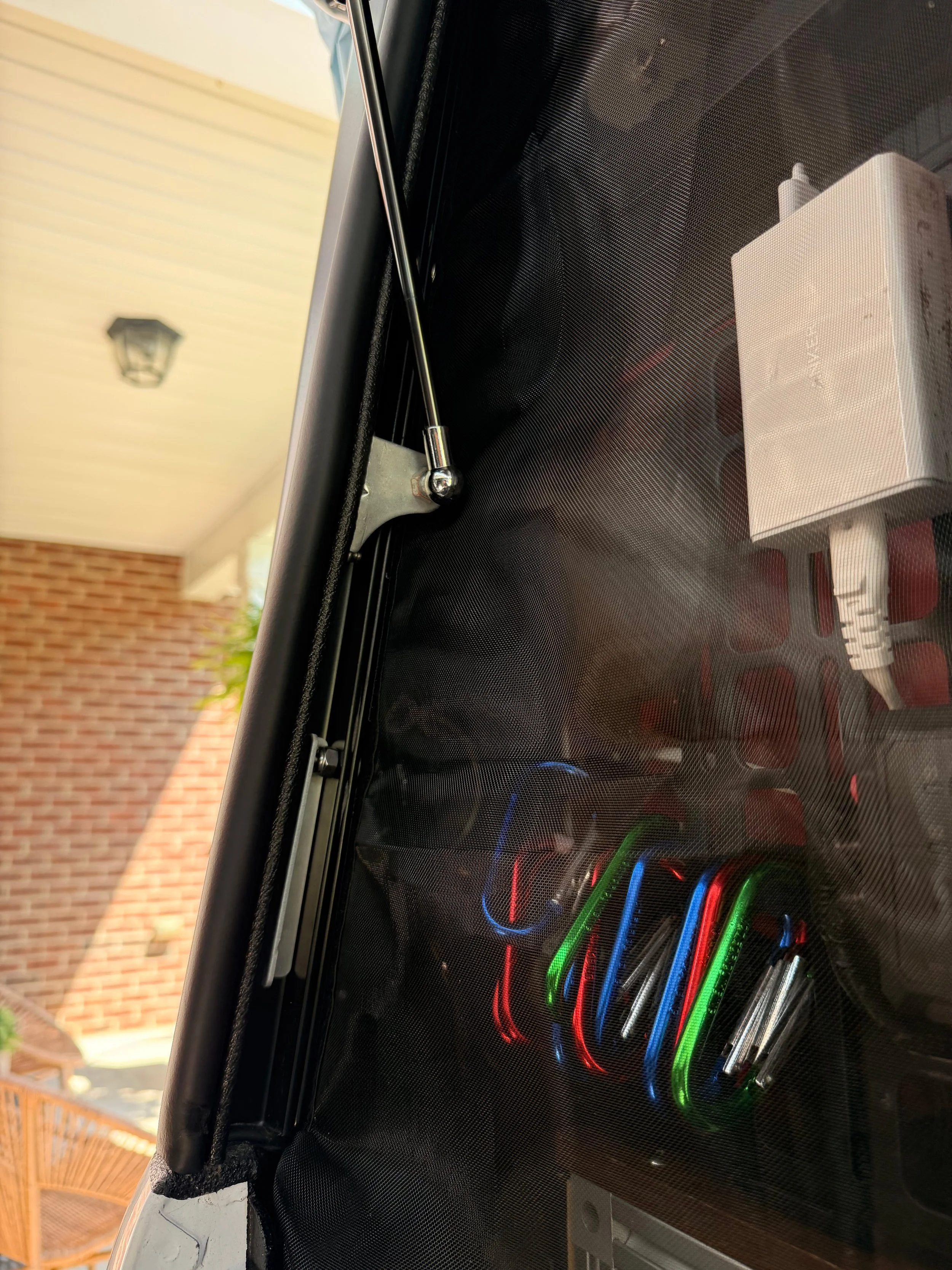 Bug screen with neon-colored accessories inside a camper.