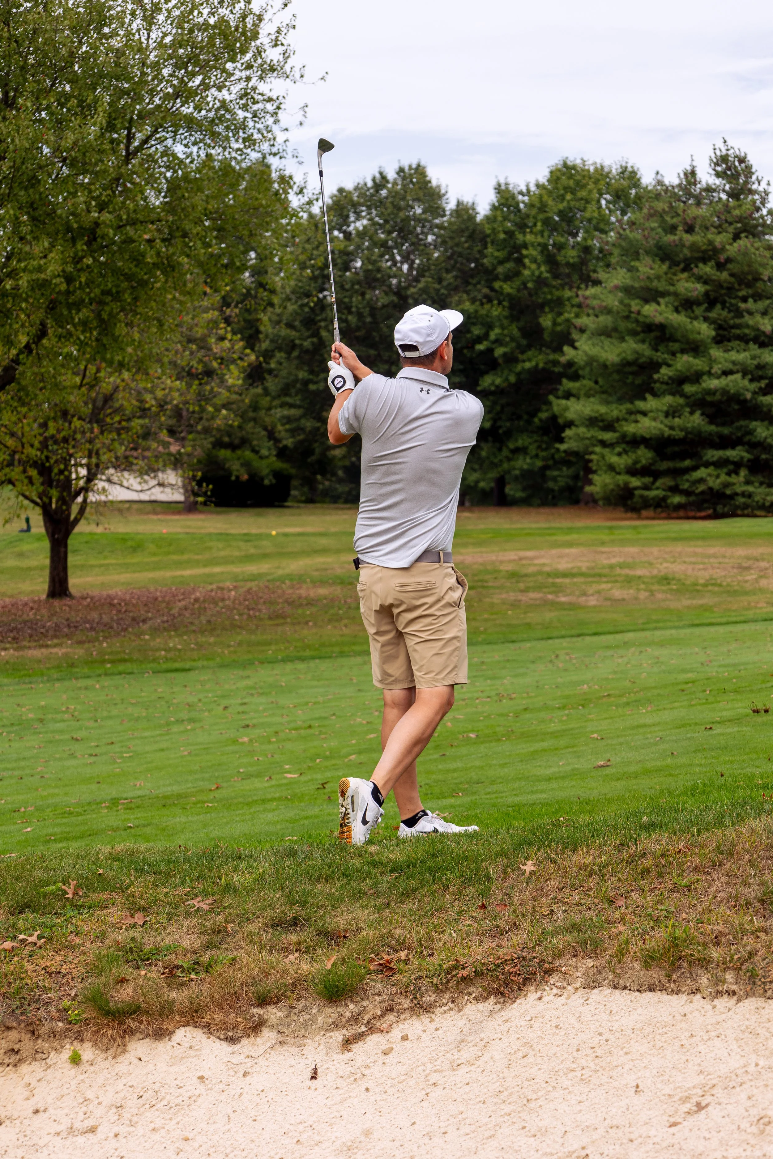 Event photography from a nonprofit golf outing, documenting golfers, course details, group moments, and candid interactions throughout the day in a natural, documentary style.
