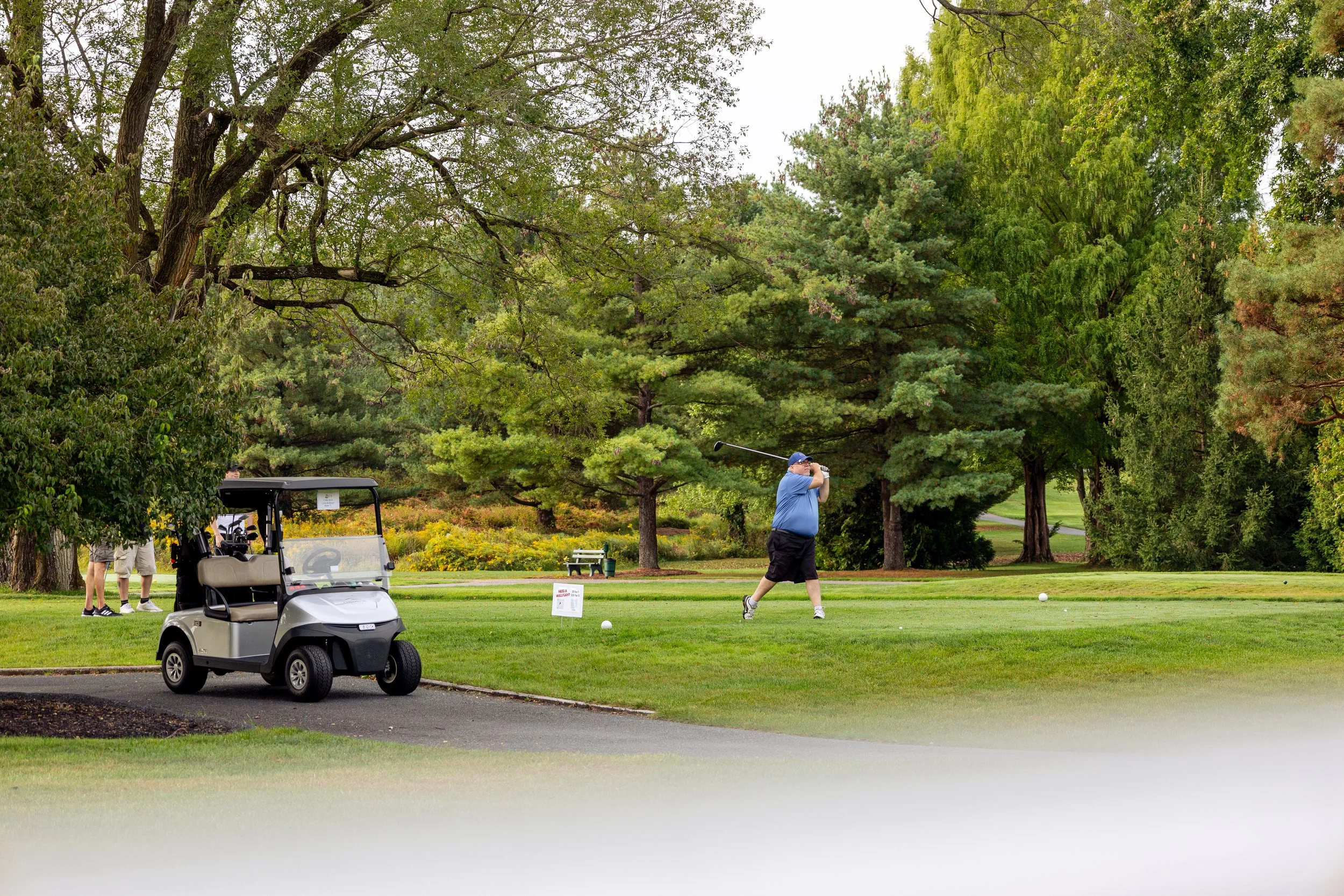 Event photography from a nonprofit golf outing, documenting golfers, course details, group moments, and candid interactions throughout the day in a natural, documentary style.