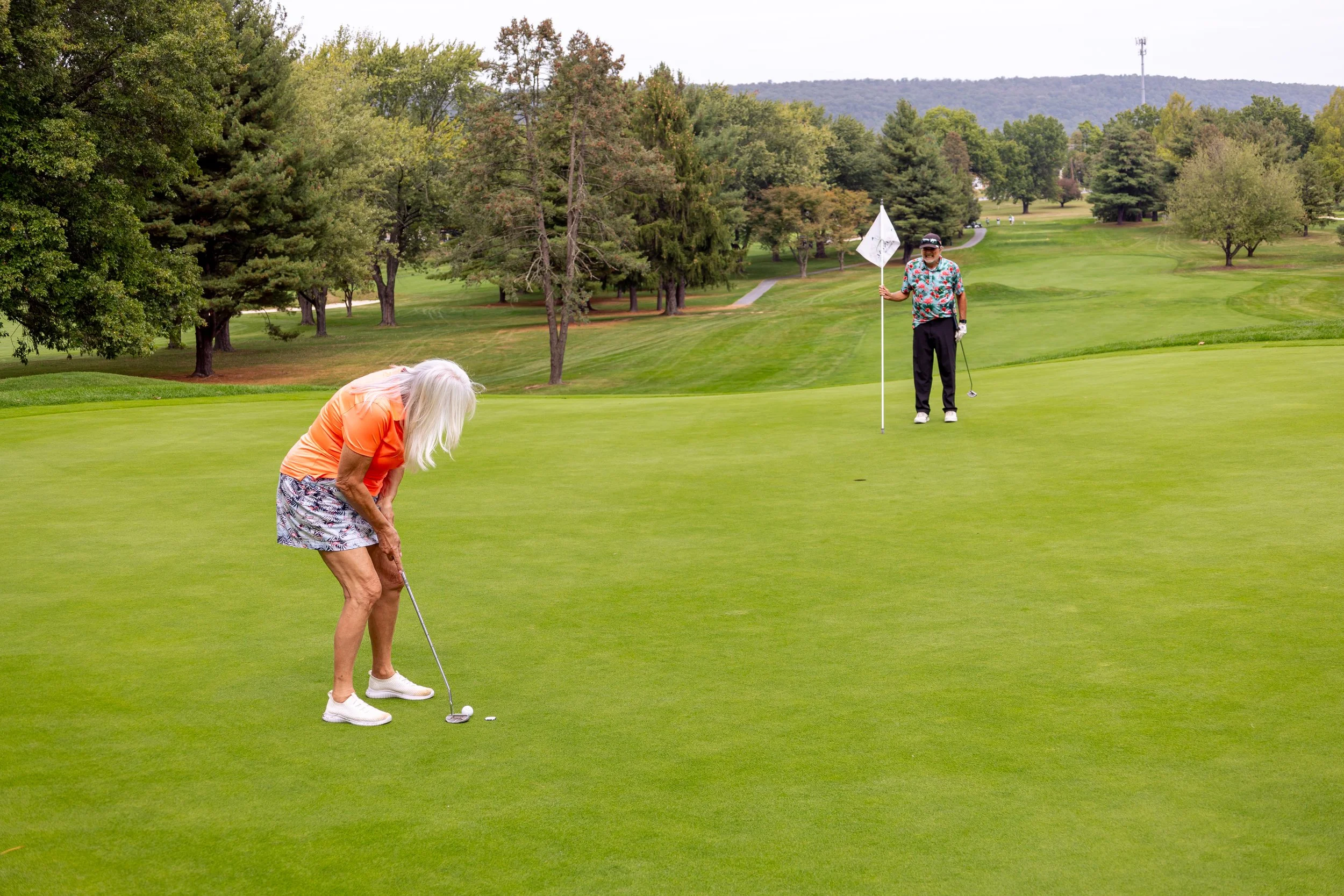 Event photography from a nonprofit golf outing, documenting golfers, course details, group moments, and candid interactions throughout the day in a natural, documentary style.