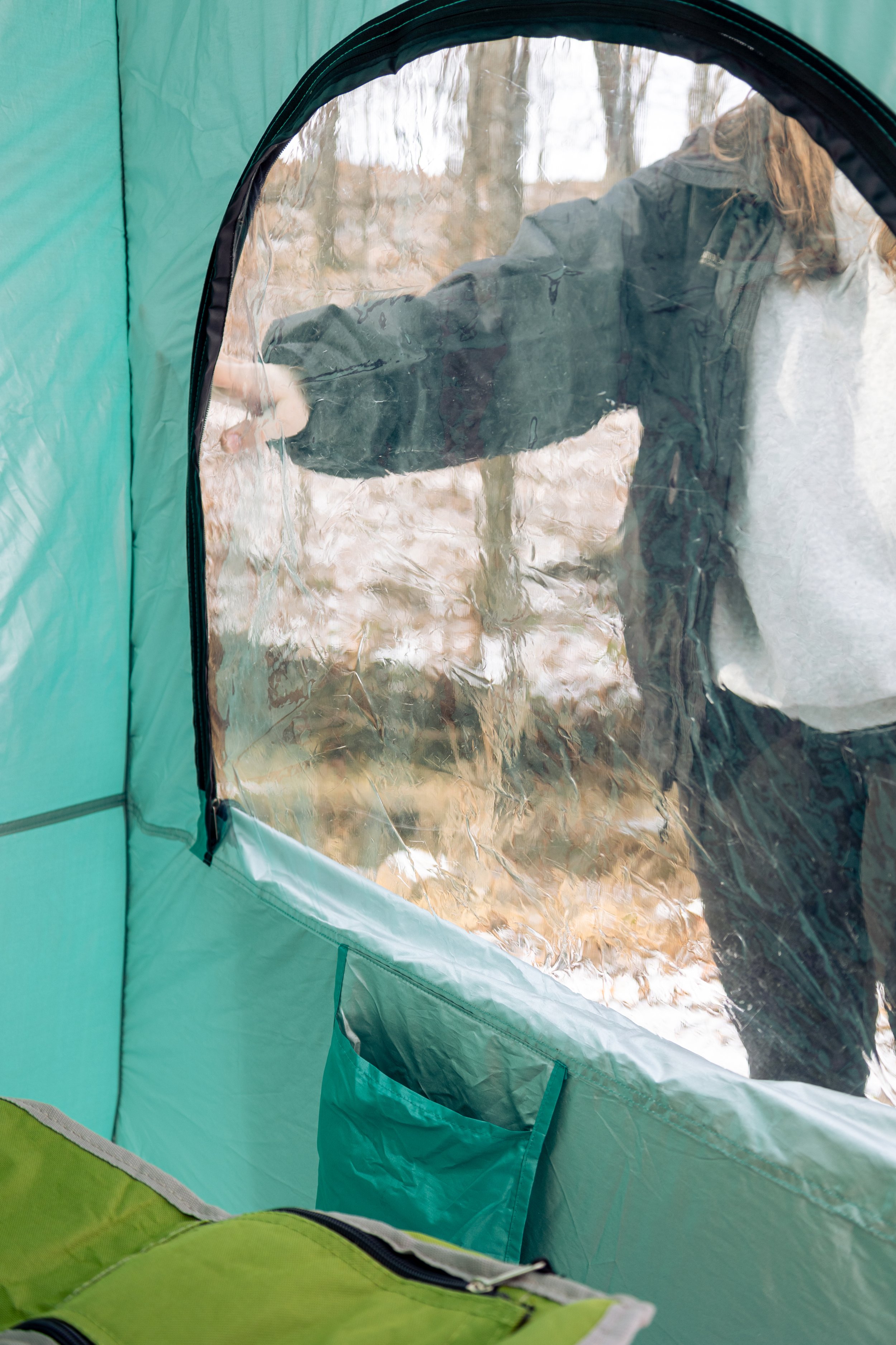 Lifestyle product photography featuring the SunHugg pop-up outdoor shelter, captured in a natural winter setting. Images highlight real-world use, setup and breakdown, interior details, branding elements, and scale to demonstrate functionality, porta