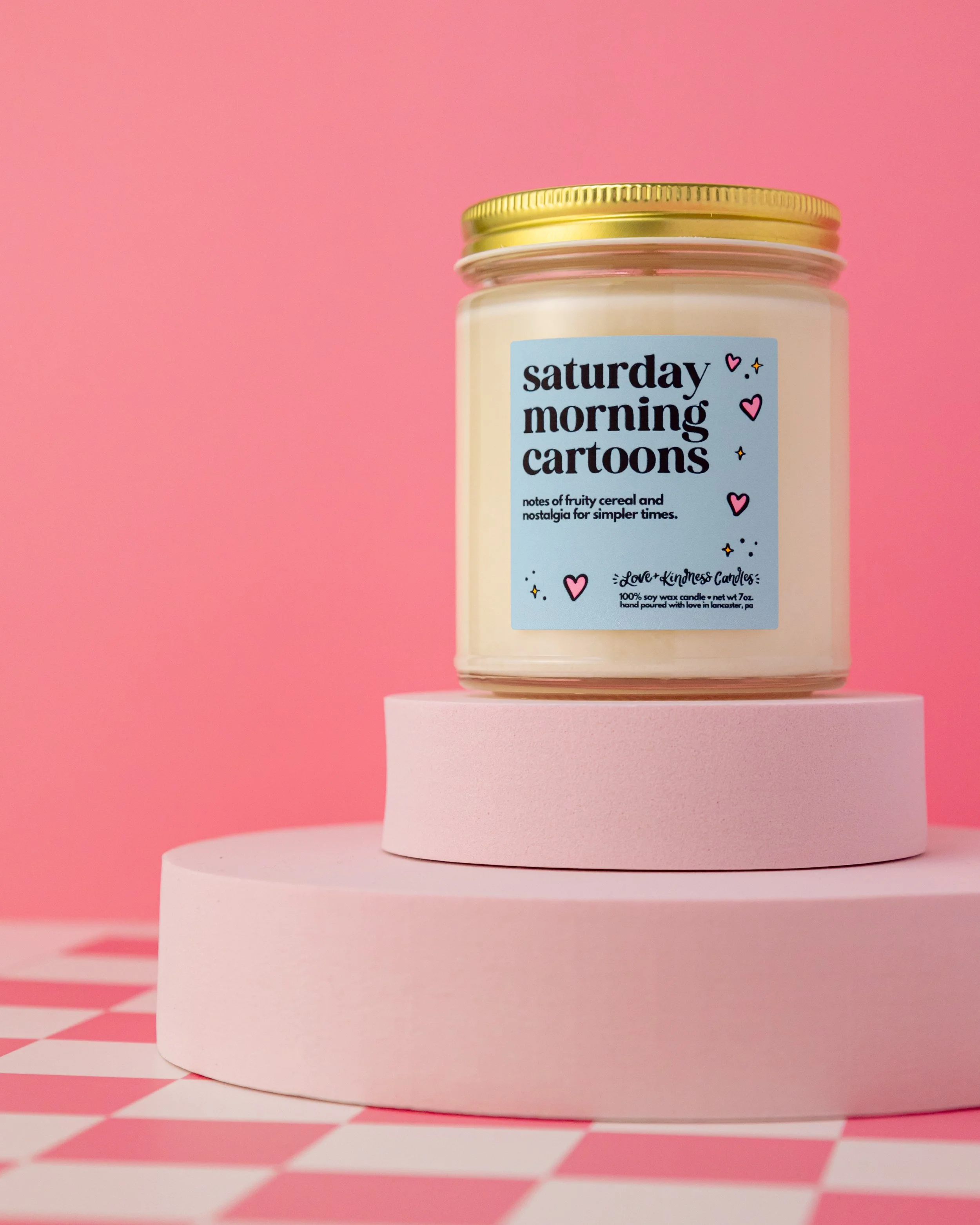 Saturday Morning Cartoon Candle from Love + Kindness Candles styled with a pink backdrop
