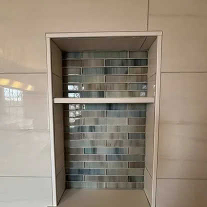 Custom tiled shower niche featuring decorative mosaic accent tile and large format wall tile installed by JK Flooring & Tile.