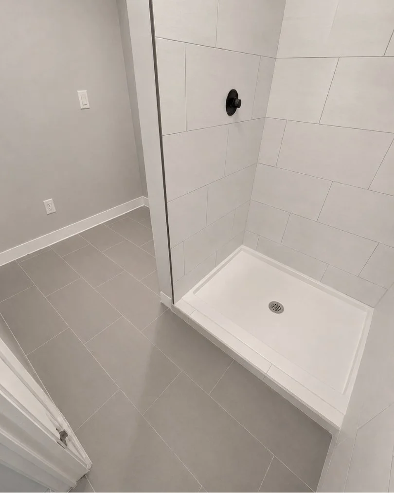 Ceramic tile shower installation with decorative accent tile, textured wall tile, and professional bathroom remodeling by JK Flooring & Tile.