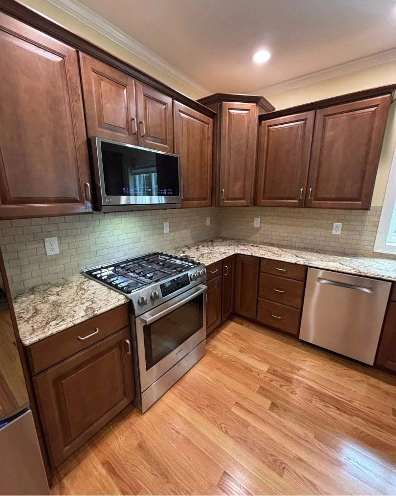 Laminate flooring installation in a modern kitchen with realistic wood-look planks, custom cabinetry, and durable low-maintenance flooring.